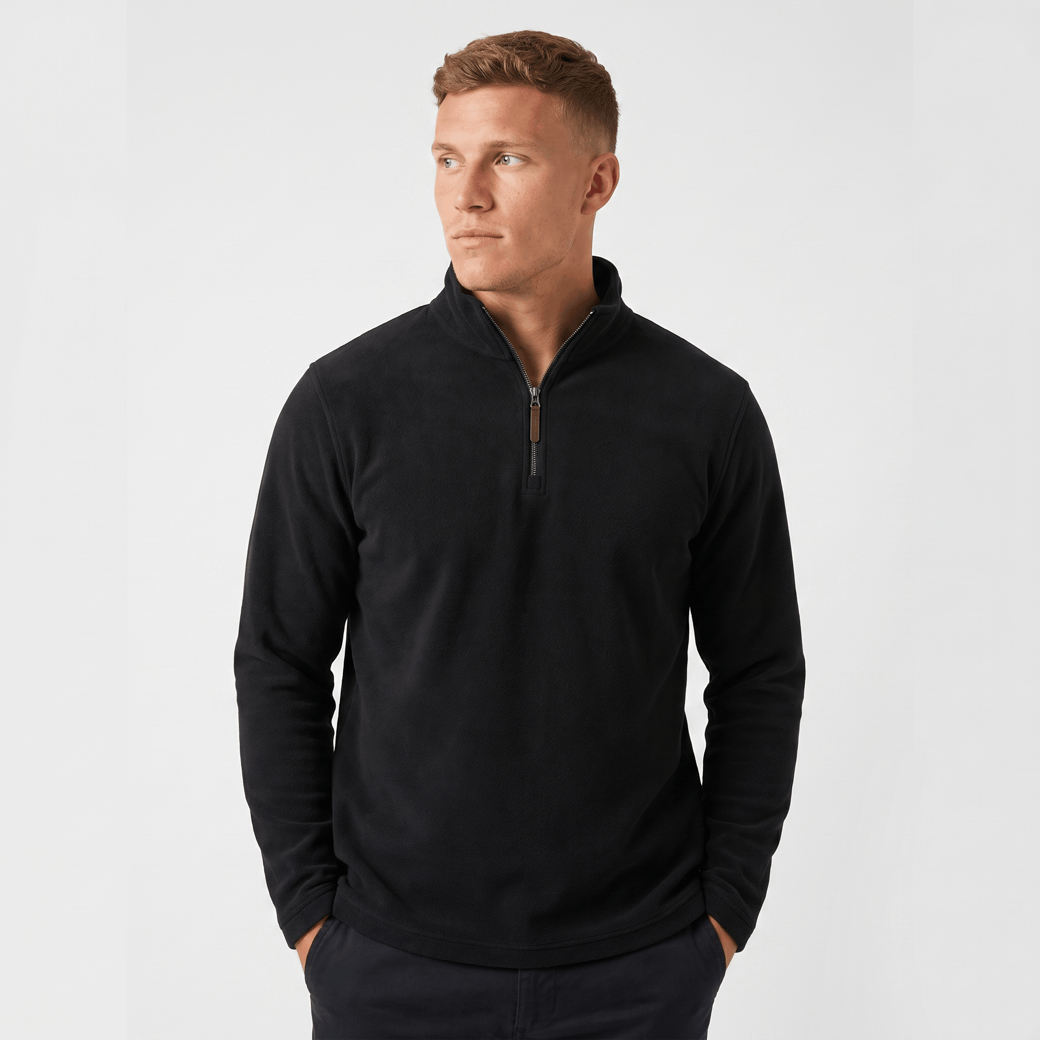 Man wearing a black quarter-zip knit sweater with a stand collar, long sleeves, and a tailored fit.