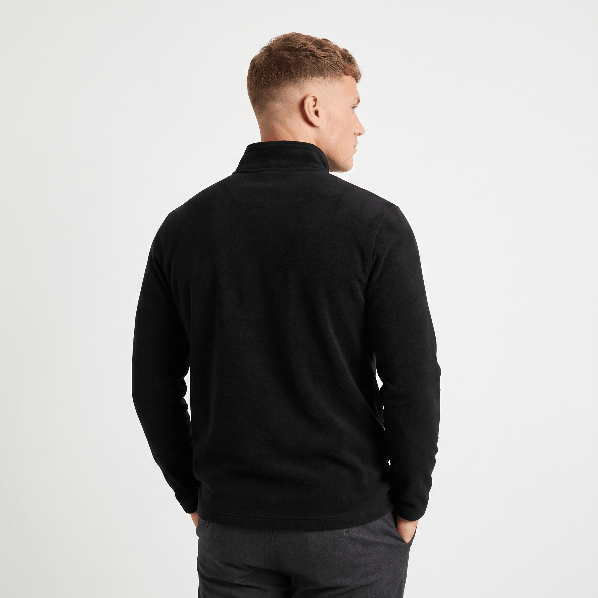 Back view of a men's black quarter-zip knit sweater with a stand collar and ribbed trim.
