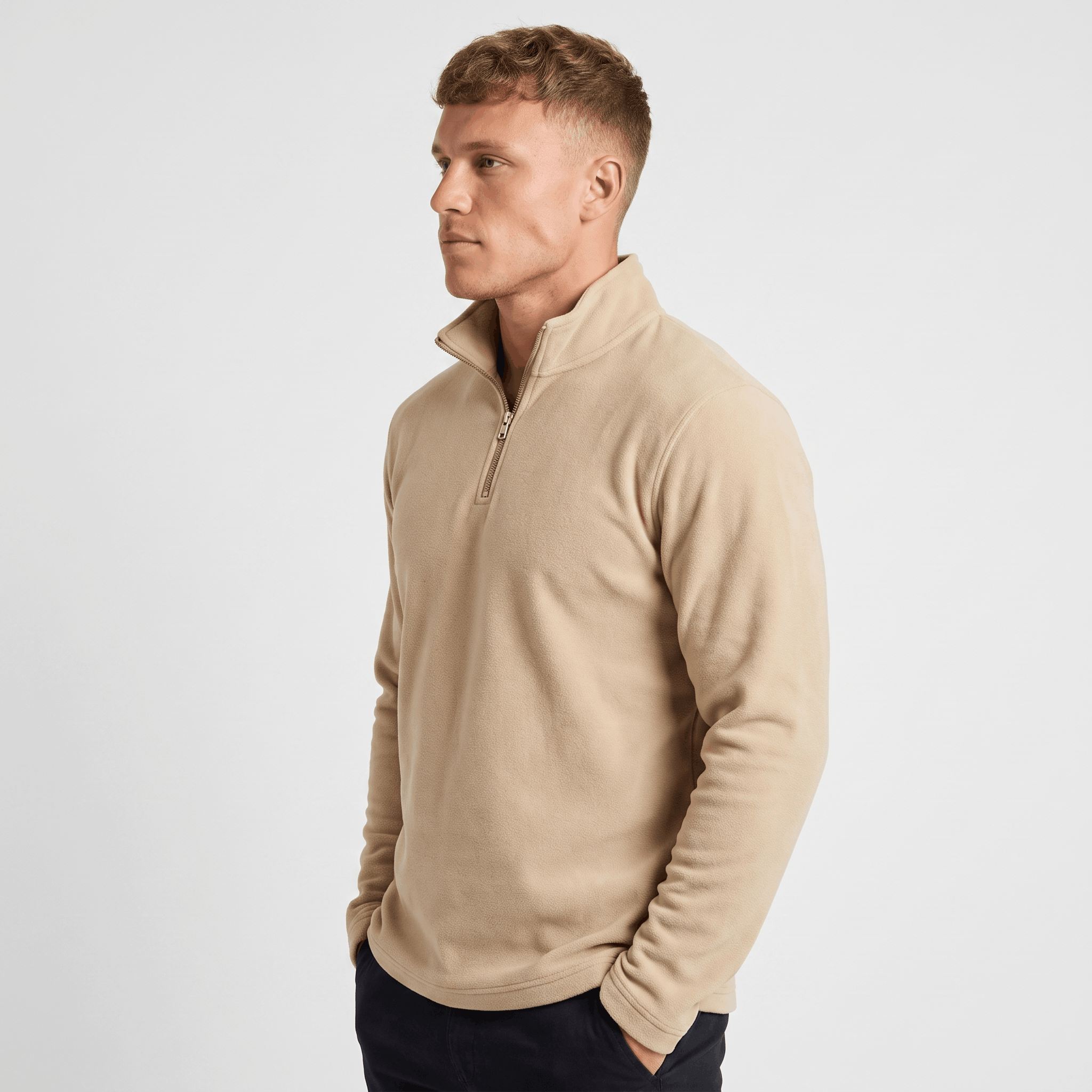 Side view of a man wearing a beige quarter-zip sweater with a stand collar and classic silhouette.