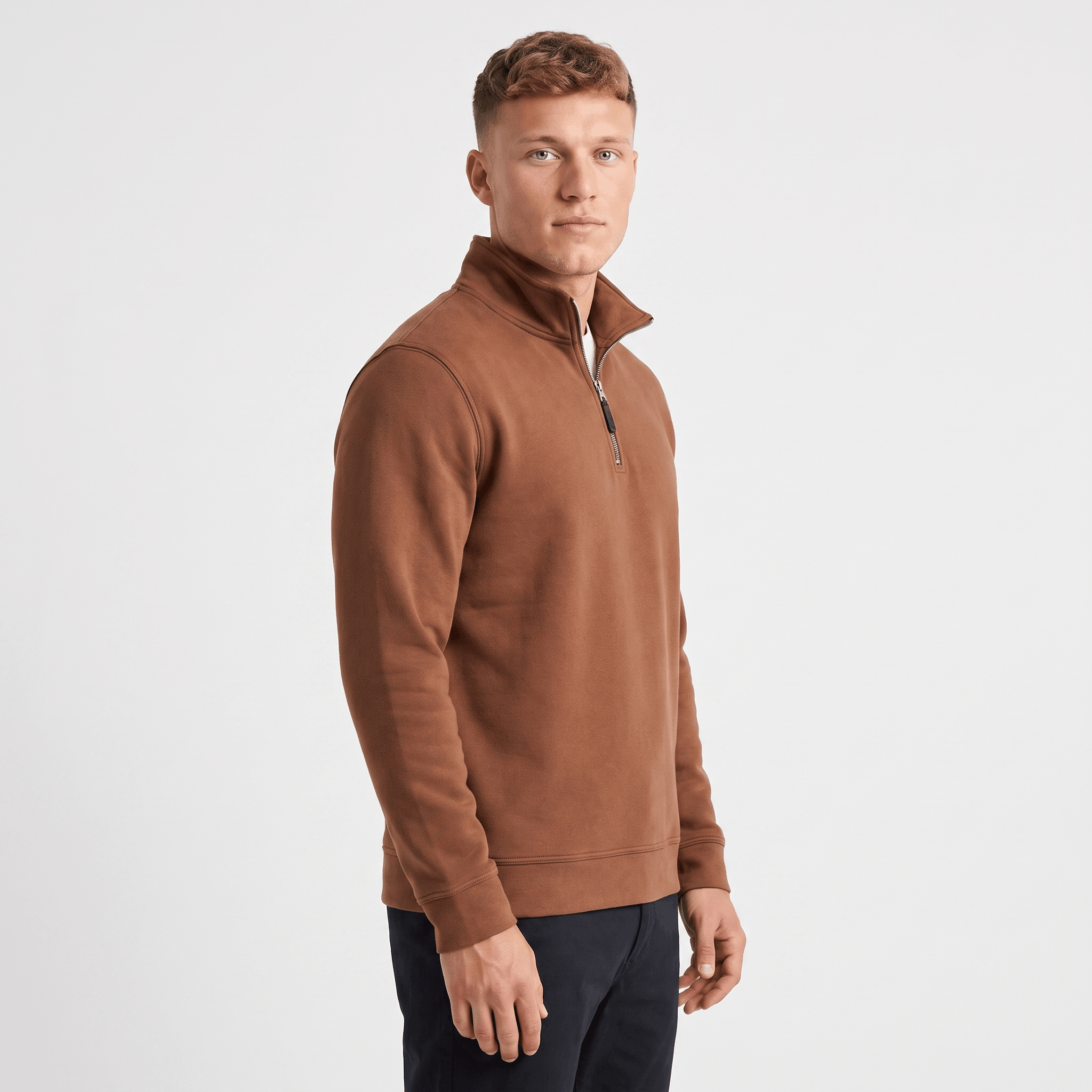 Side view of a man wearing a brown quarter-zip sweater with a stand collar and ribbed trim.
