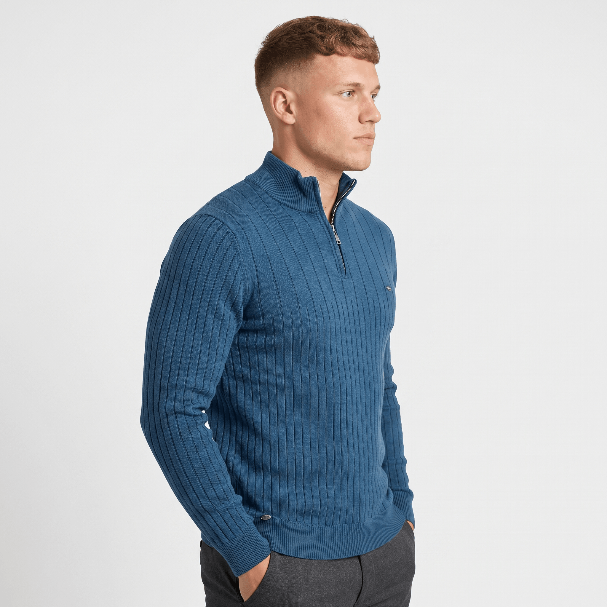 Side view of a man wearing a blue ribbed quarter-zip sweater with a stand collar and fitted silhouette.