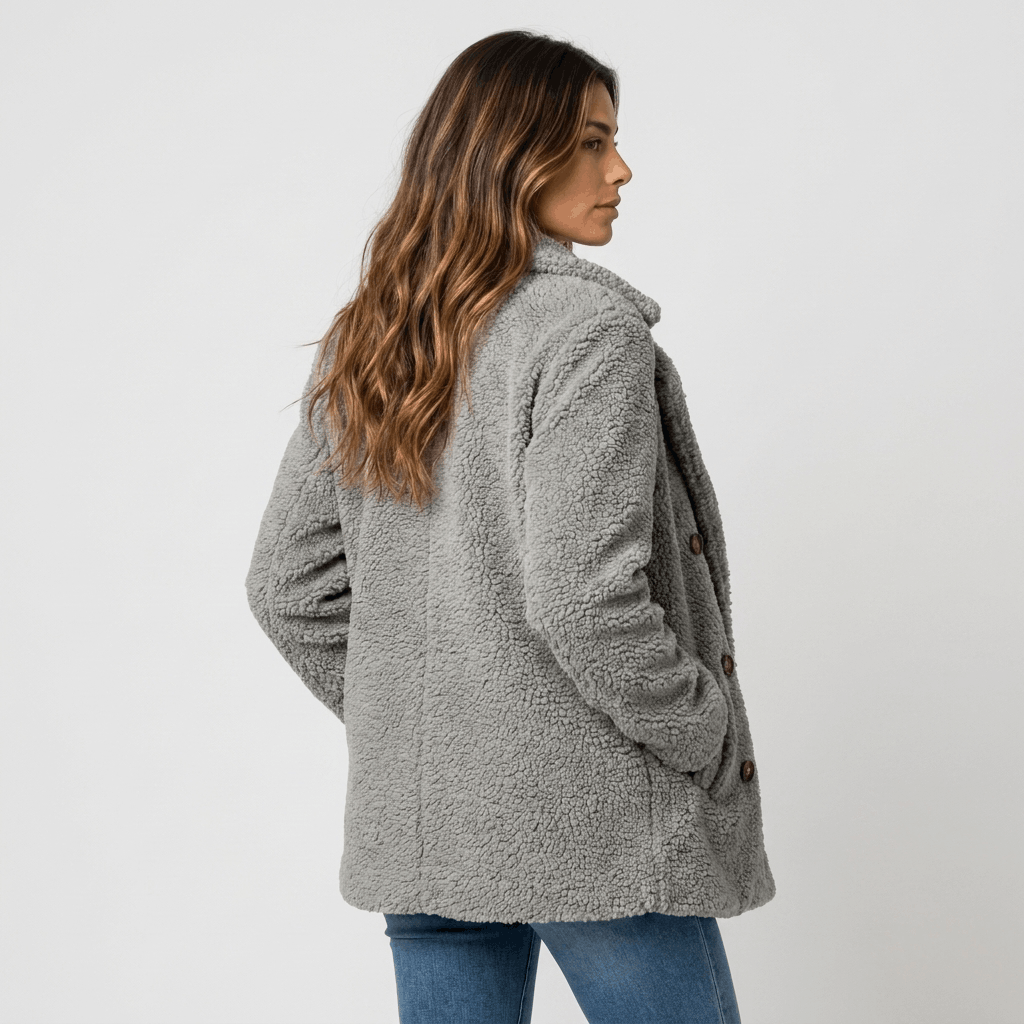 Back view of a woman wearing a light gray textured coat with a structured silhouette.