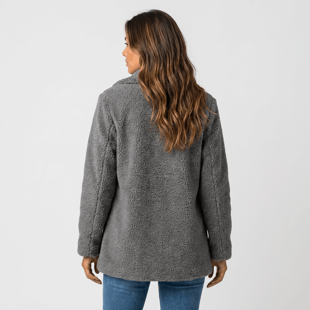 Back view of a woman wearing a dark gray textured coat with a structured silhouette and long sleeves.