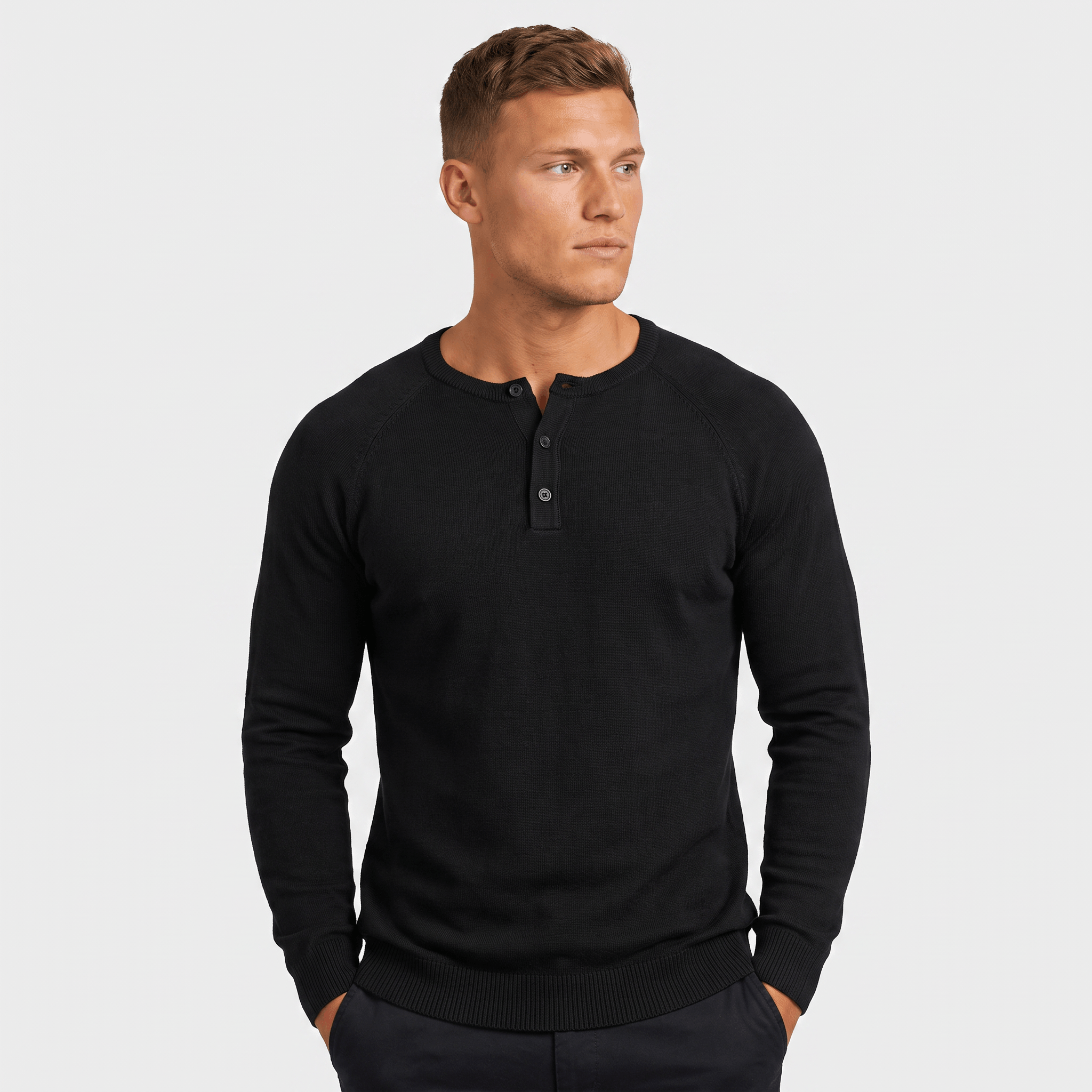 Man wearing a black waffle knit Henley sweater featuring a three-button neckline, textured knit fabric, and classic fit.