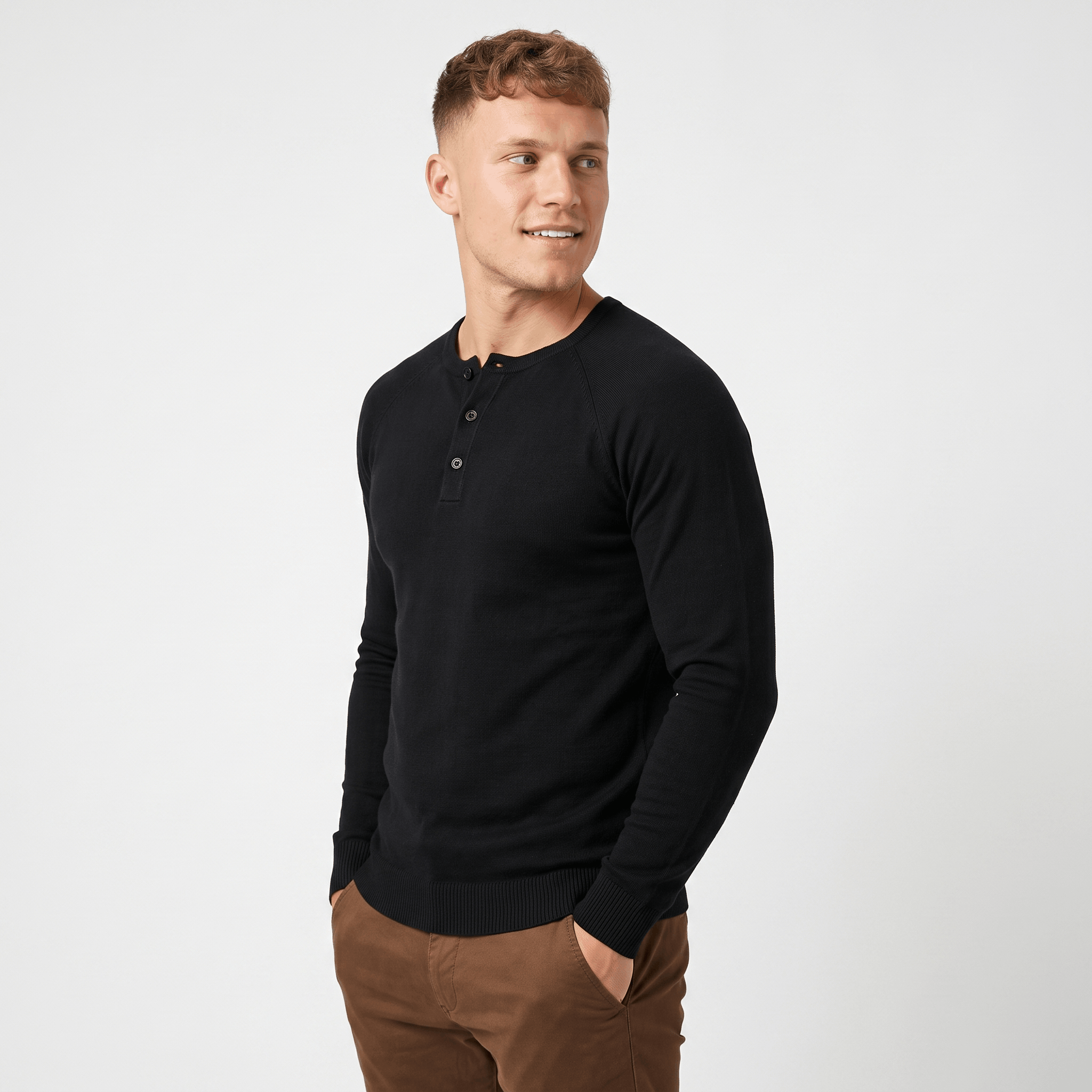 Side view of a man wearing a black waffle knit Henley sweater with a textured waffle knit pattern and tailored silhouette.