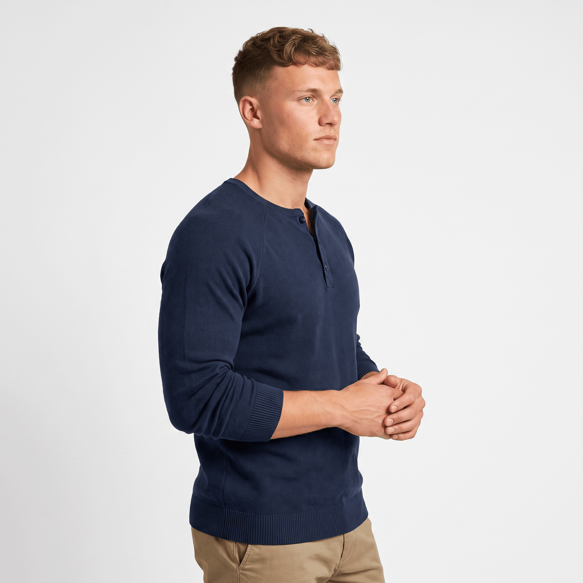 Side view of a man wearing a navy waffle knit Henley sweater featuring a three-button placket and slim-fit silhouette.