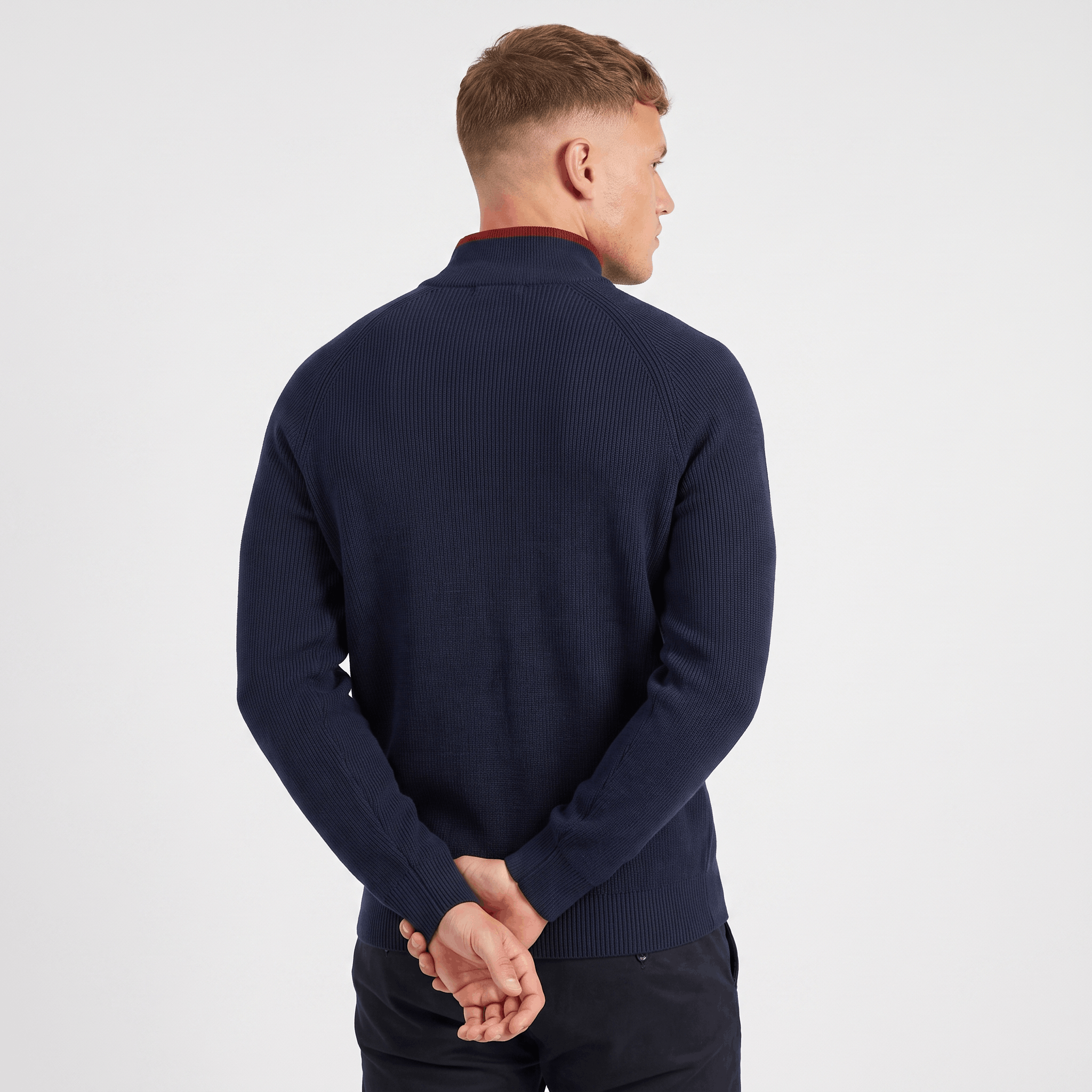 Back view of a men's navy ribbed quarter-zip knit sweater with a stand collar and ribbed construction.