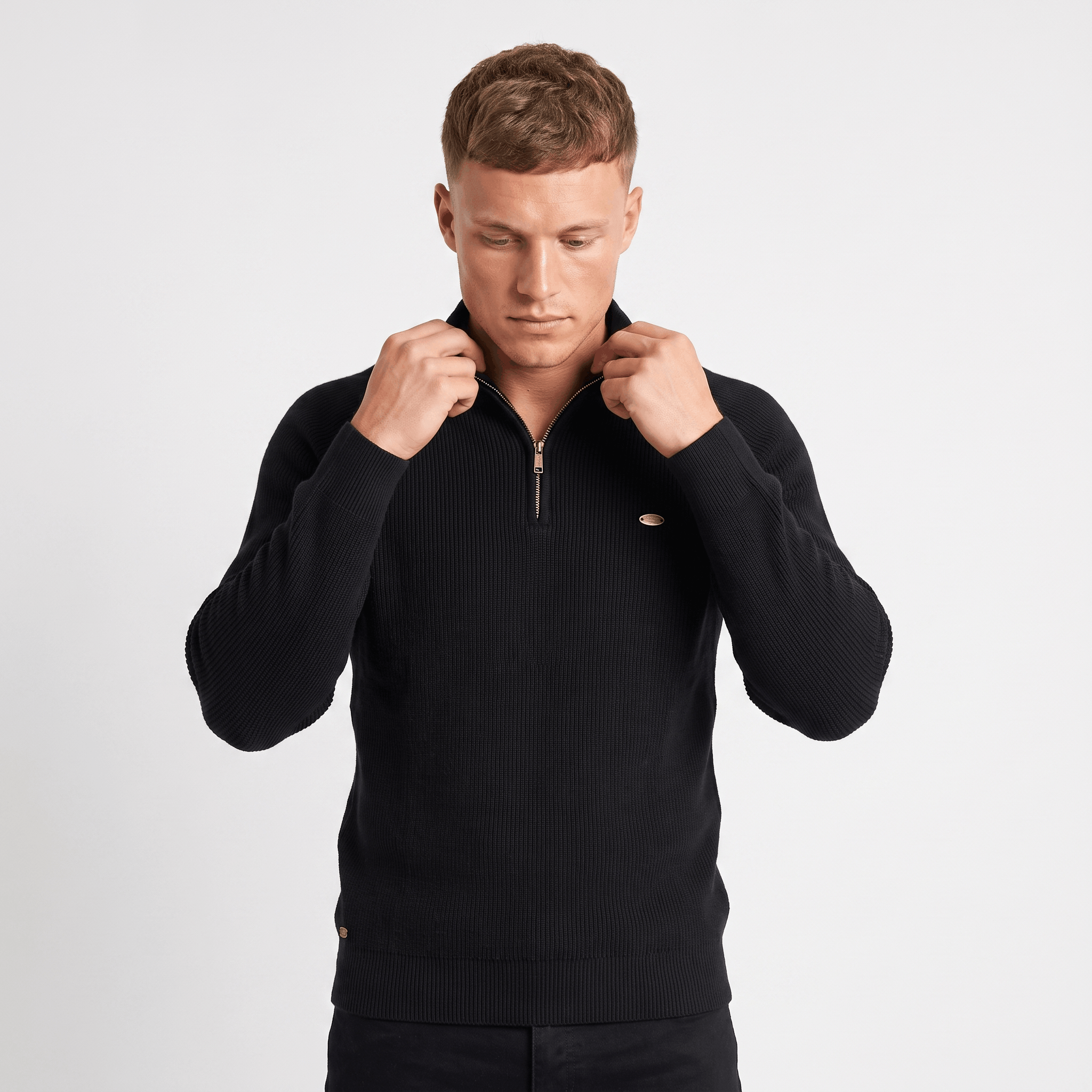 Man wearing a black ribbed quarter-zip knit sweater featuring a stand collar, long sleeves, and a classic slim fit.