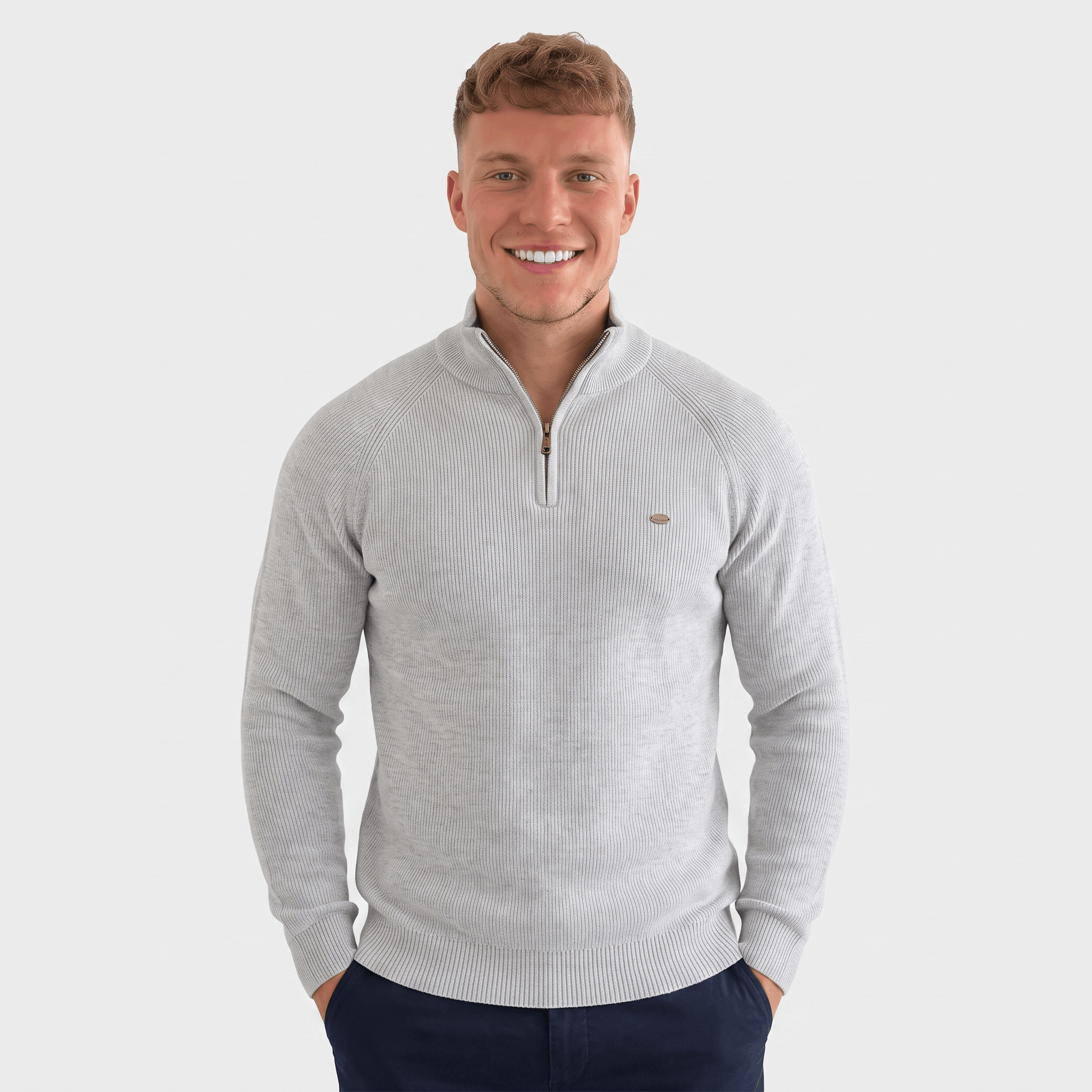 Man wearing a light gray ribbed quarter-zip knit sweater with a stand collar, long sleeves, and a modern slim fit.