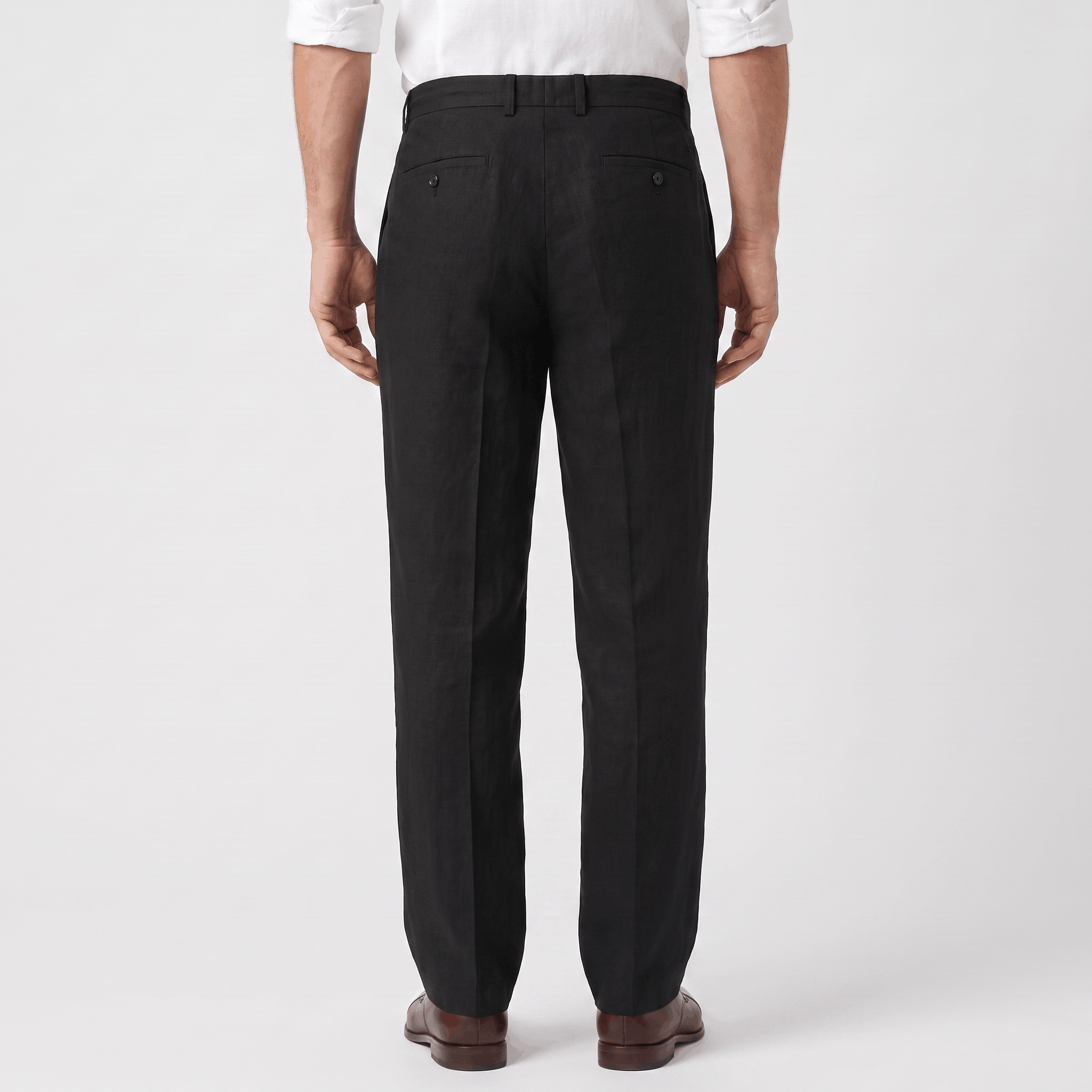 Back view of men's black linen drawstring pants with an elastic waistband and relaxed straight-leg fit.