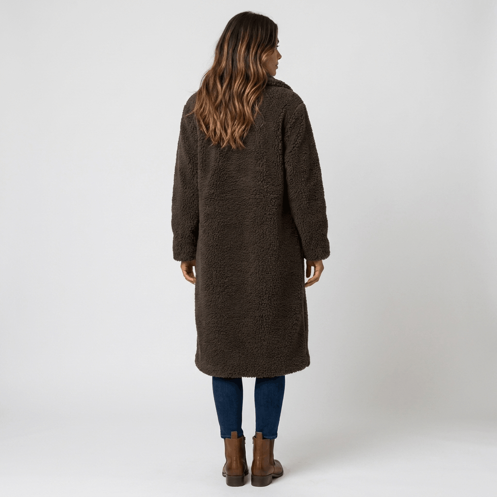 Back view of a woman wearing a dark brown long coat with a structured silhouette and long sleeves.