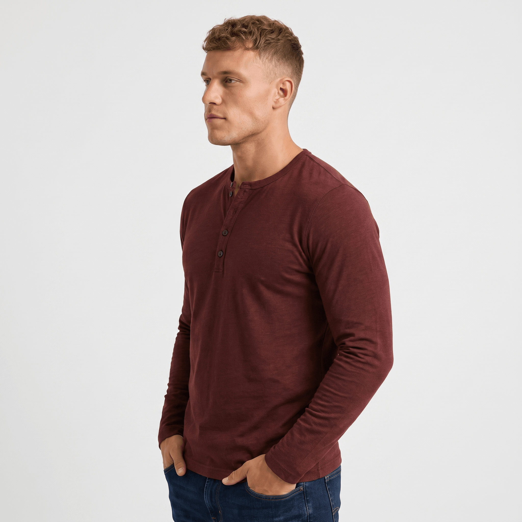 Side view of a man wearing a burgundy long-sleeve Henley shirt featuring a three-button neckline and tailored silhouette.