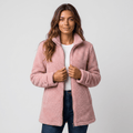 Woman wearing a pink textured fleece jacket with a stand collar, front zip closure, long sleeves, and relaxed fit over a white top and blue jeans.