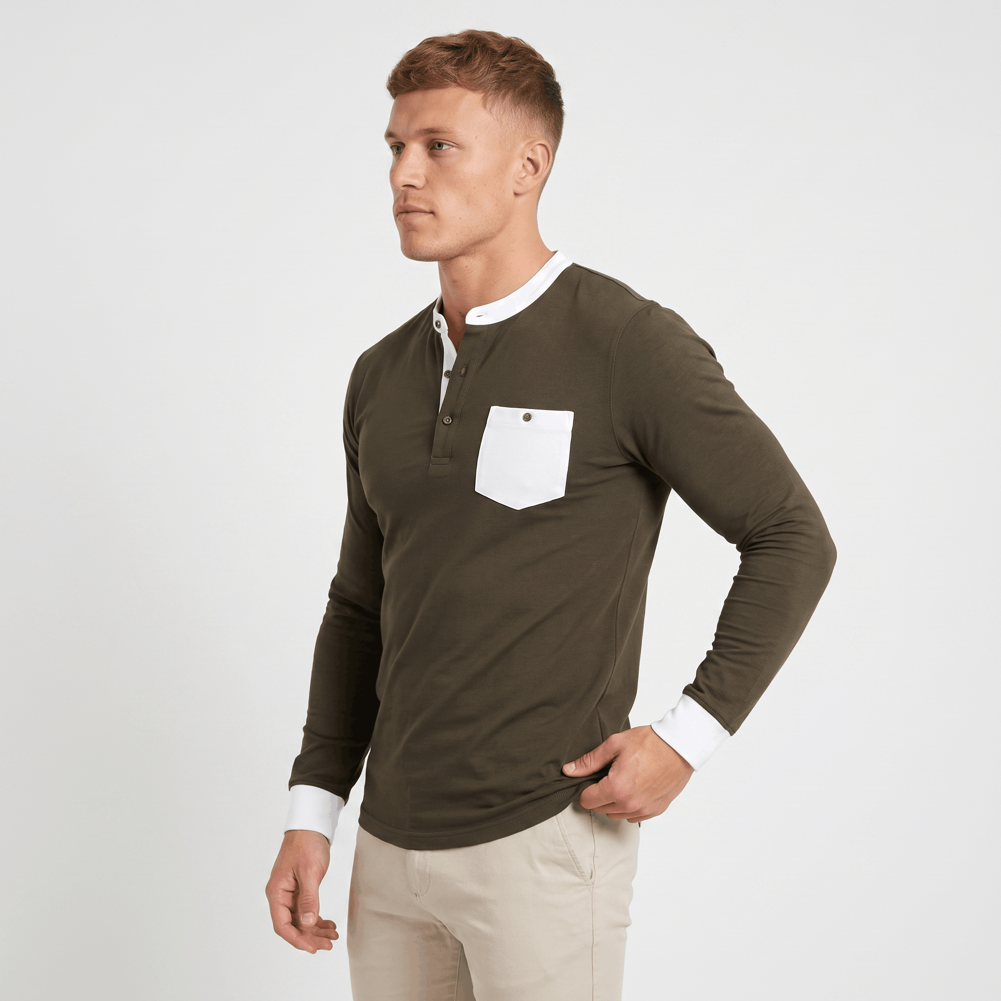 Man wearing an olive green long-sleeve Henley sweater with a white contrast chest pocket and button placket.