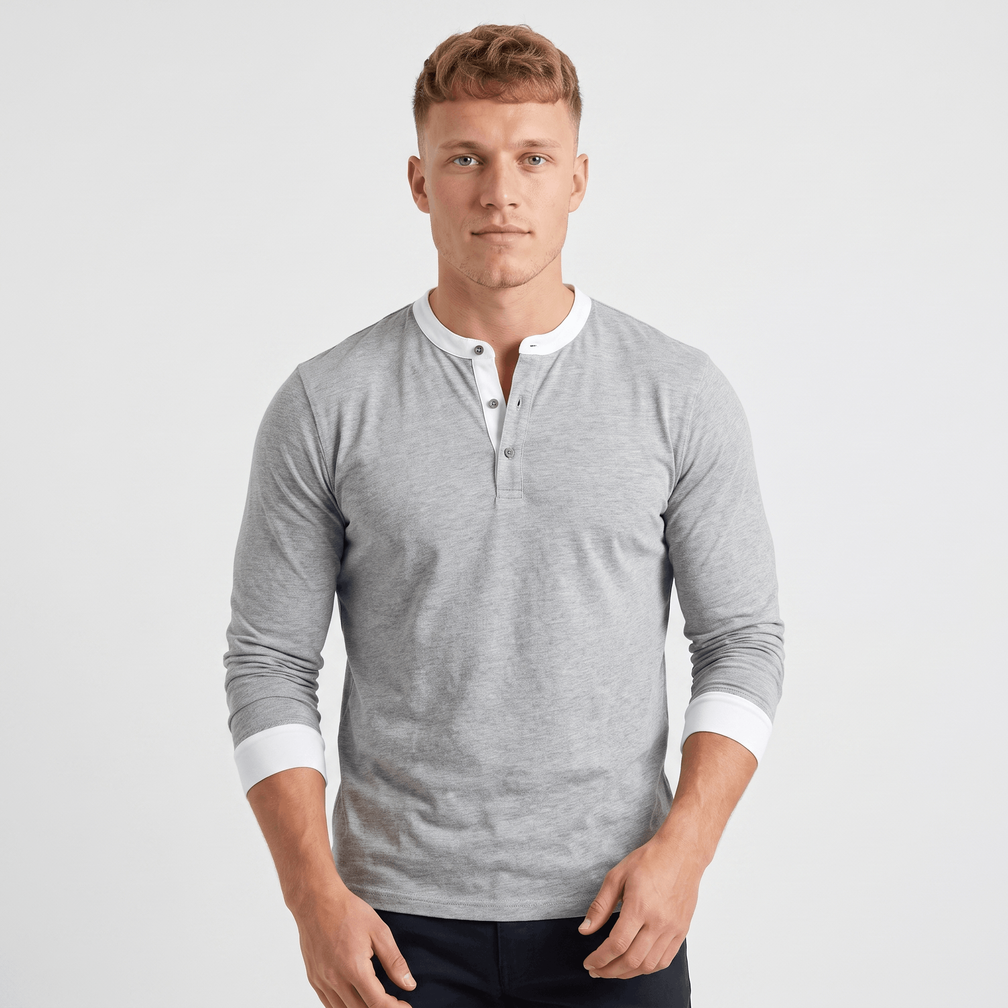 Man wearing a light gray long-sleeve Henley sweater with a white contrast placket, three-button neckline, chest logo, and a classic slim fit.