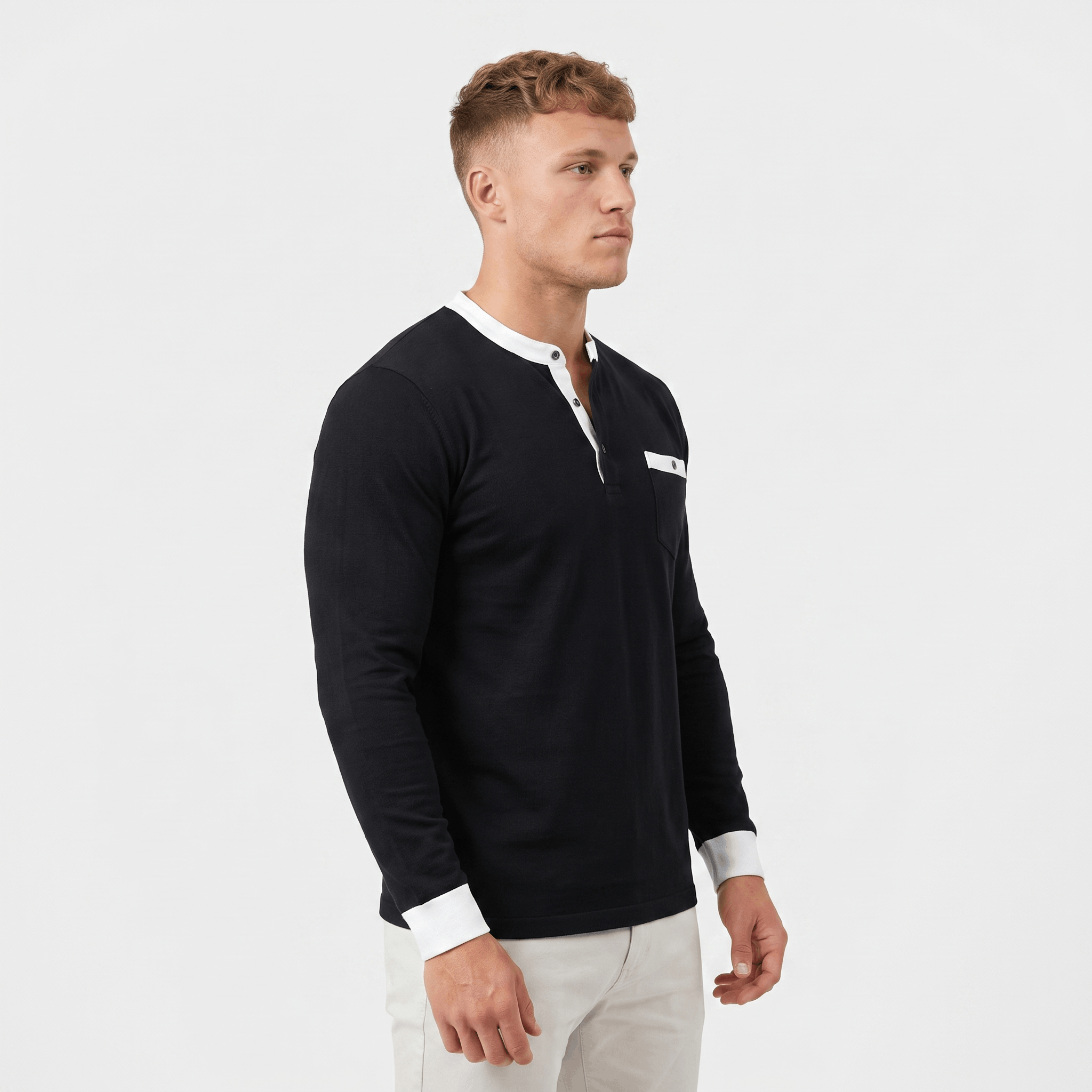 Side view of a man wearing a black long-sleeve Henley sweater featuring a white contrast placket, ribbed cuffs, and tailored fit.