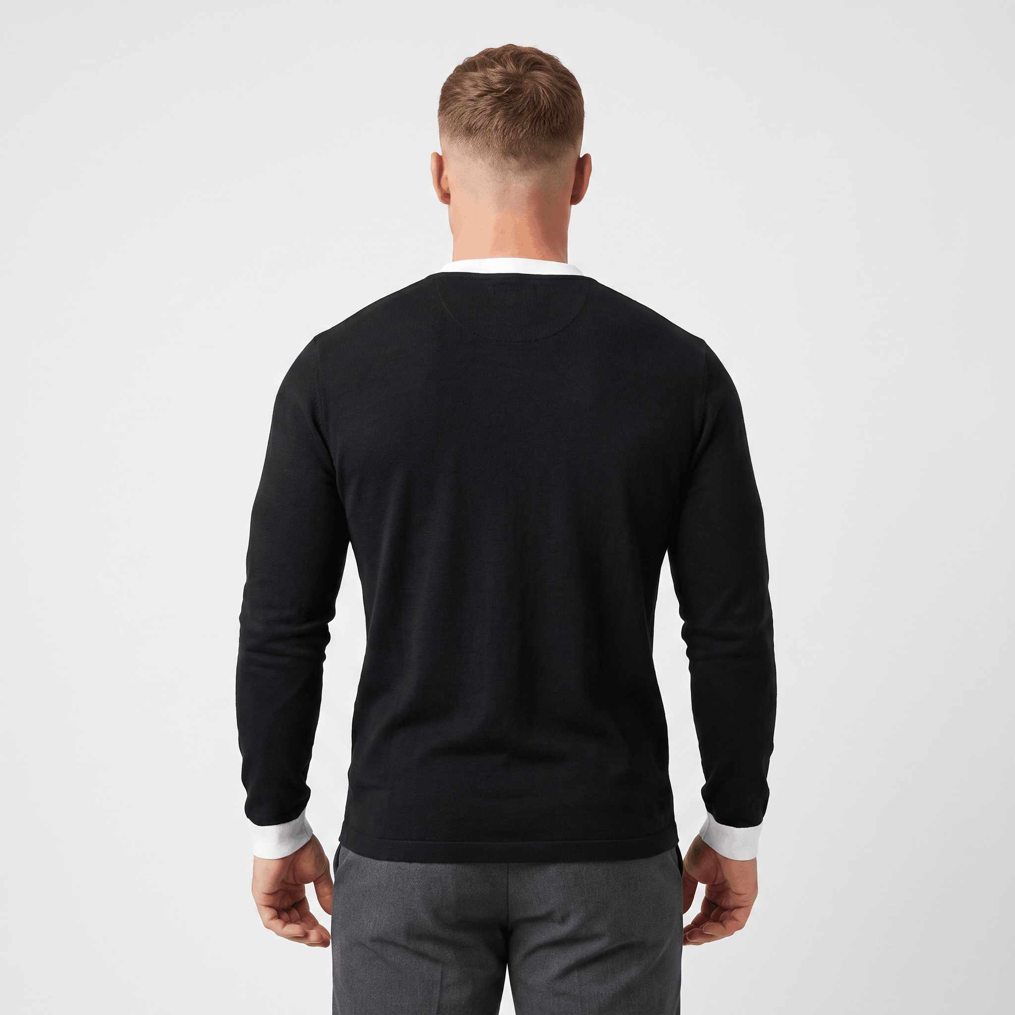 Back view of a men's black long-sleeve Henley sweater with a clean minimalist design and ribbed hem.