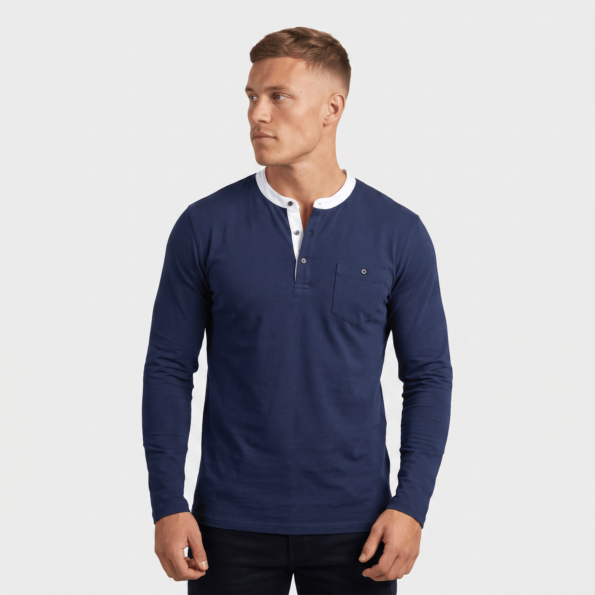 Man wearing a blue long-sleeve Henley sweater with a white contrast placket, three-button neckline, and slim fit.