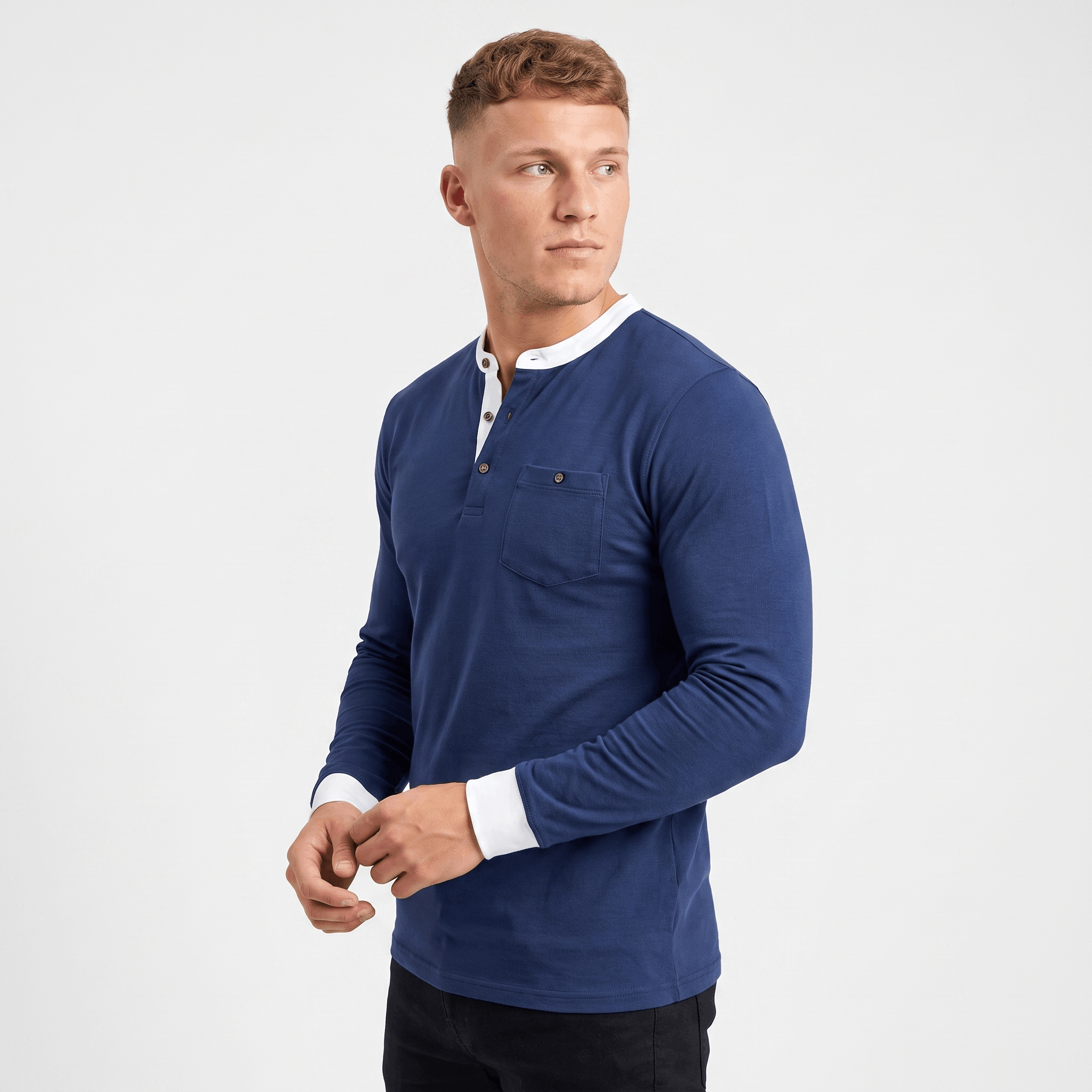 Side view of a man wearing a blue long-sleeve Henley sweater featuring a white contrast neckline and ribbed cuffs.