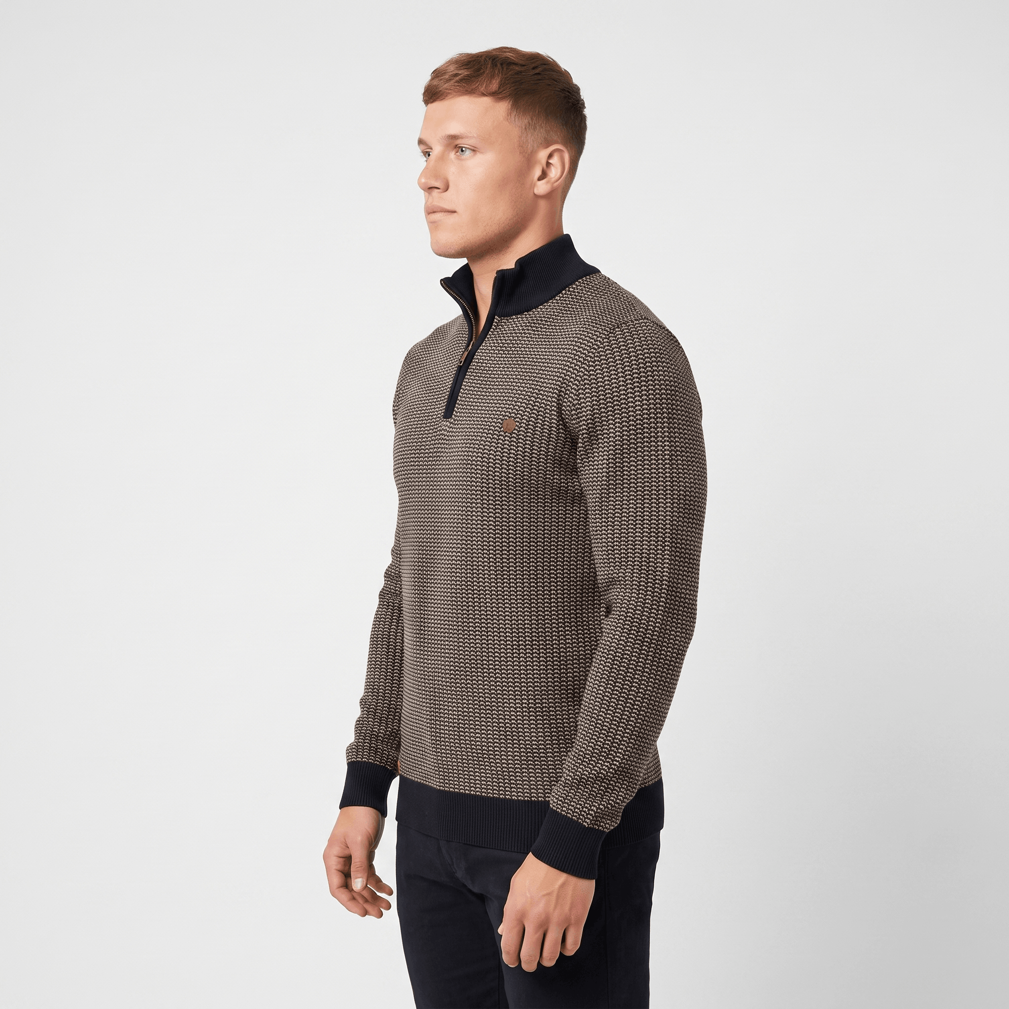 Side view of a man wearing a brown textured quarter-zip sweater with a stand collar and tailored silhouette.
