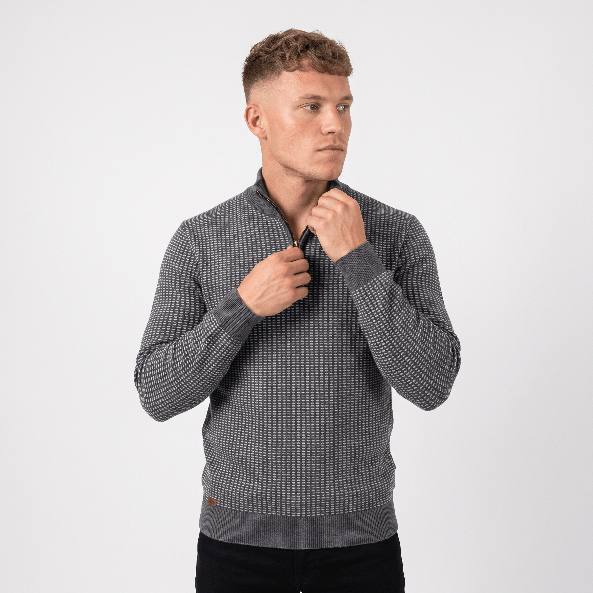 Man wearing a gray textured quarter-zip knit sweater with a stand collar, long sleeves, and a modern fitted silhouette.