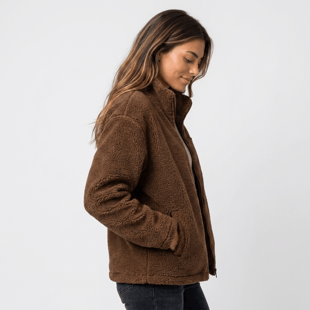 Side view of a woman wearing a brown textured fleece jacket with a stand collar and front zip closure.