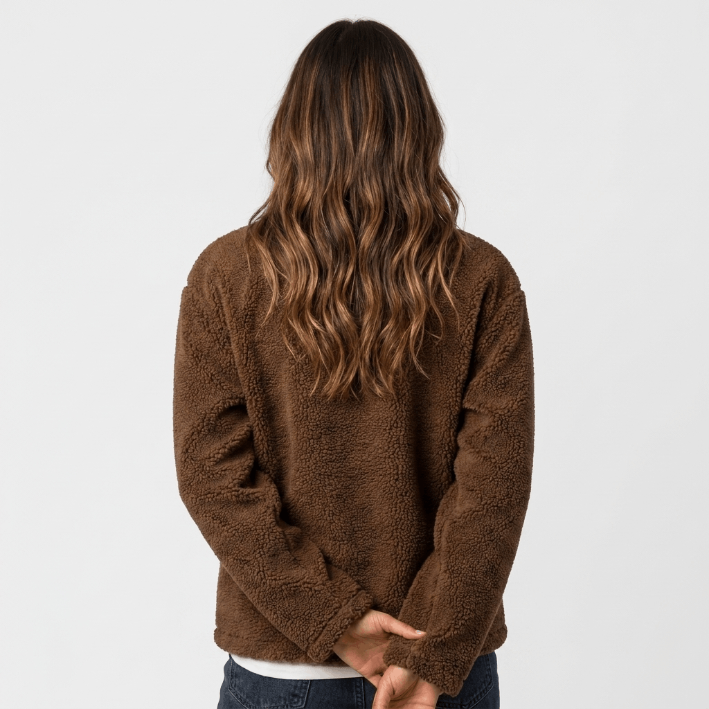 Back view of a woman wearing a brown textured fleece jacket with a relaxed silhouette and long sleeves.