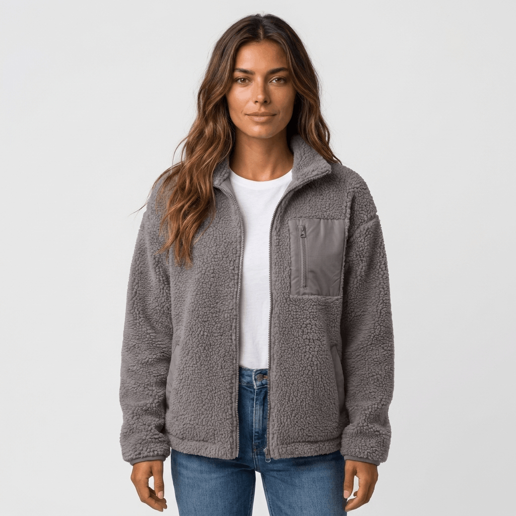 Woman wearing a gray textured fleece jacket with a stand collar, front zip closure, and relaxed fit over a white top and blue jeans.