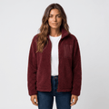 Woman wearing a burgundy textured fleece jacket with a stand collar, front zip closure, long sleeves, and relaxed fit over a white top and blue jeans.