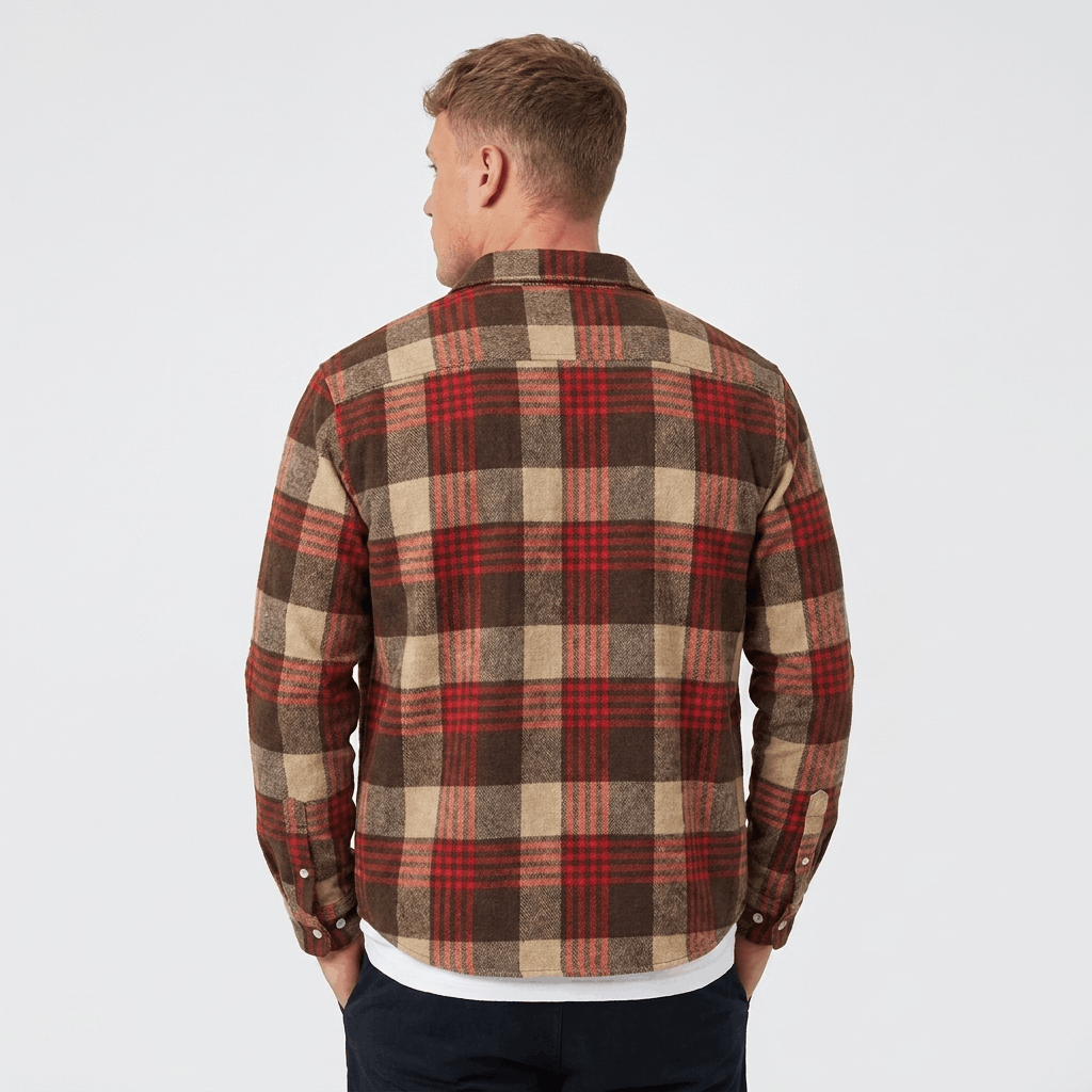 Back view of a man wearing a red, brown, and beige plaid overshirt jacket with a relaxed silhouette.