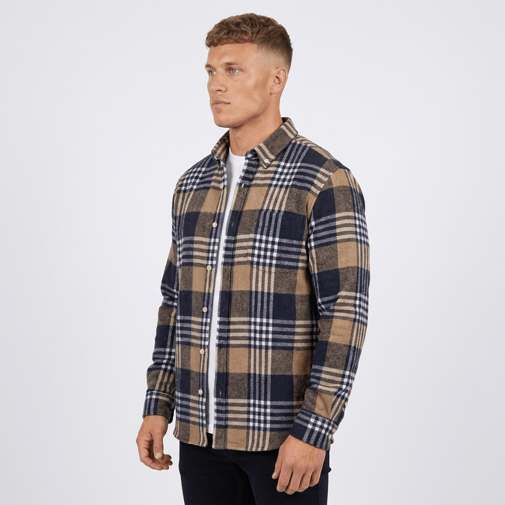 Side view of a man wearing a navy, beige, and white plaid overshirt jacket with a button-front closure, spread collar, and relaxed fit.