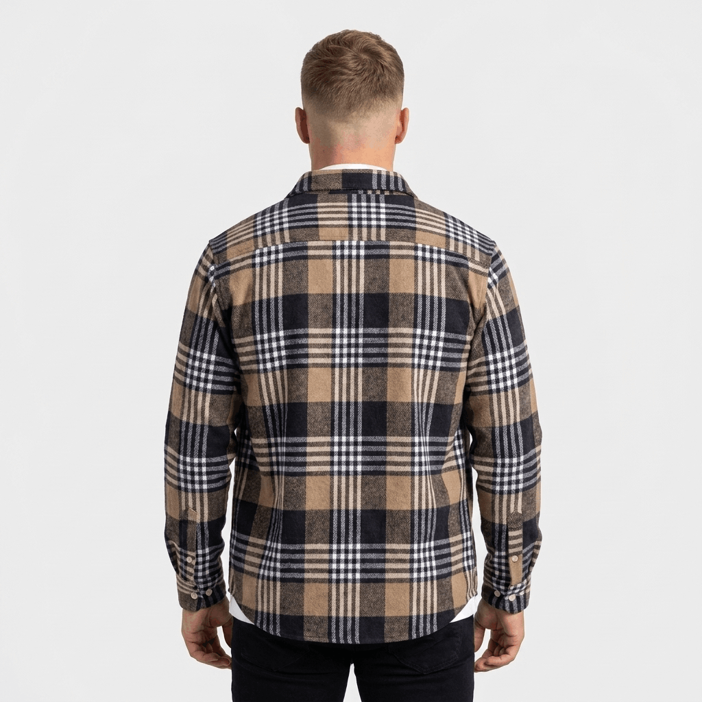 Back view of a man wearing a navy, beige, and white plaid overshirt jacket with a relaxed silhouette and long sleeves.