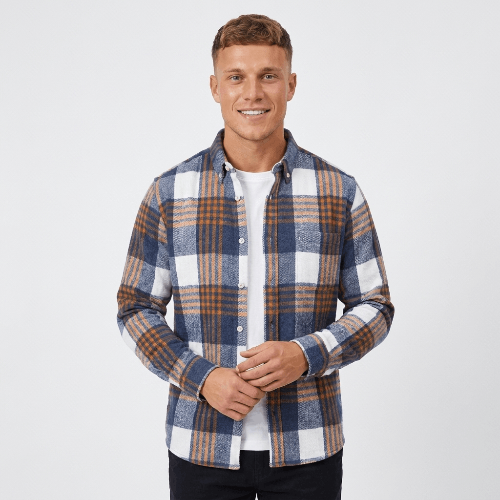 Front view of a man wearing a blue, white, and brown plaid overshirt jacket with a button-front closure, chest pockets, and long sleeves.