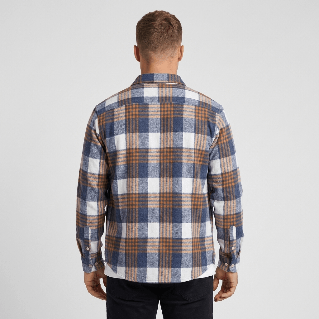 Back view of a man wearing a blue, white, and brown plaid overshirt jacket with a relaxed silhouette.