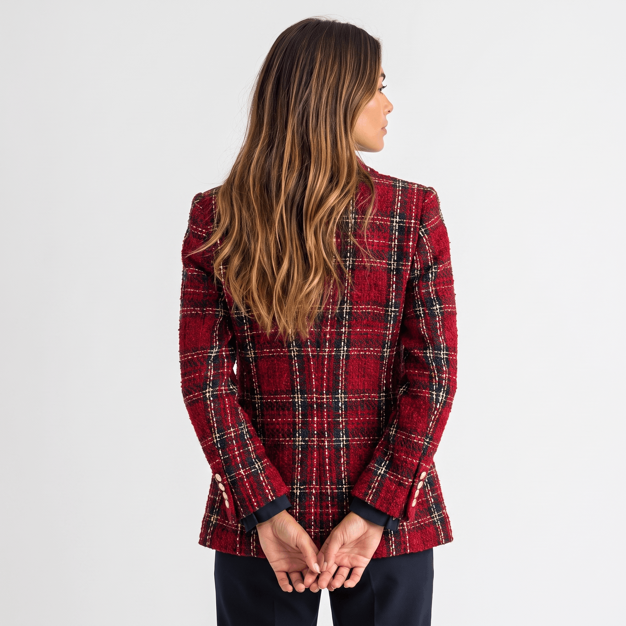 Back view of a woman wearing a red plaid tweed blazer with a tailored silhouette and long sleeves.