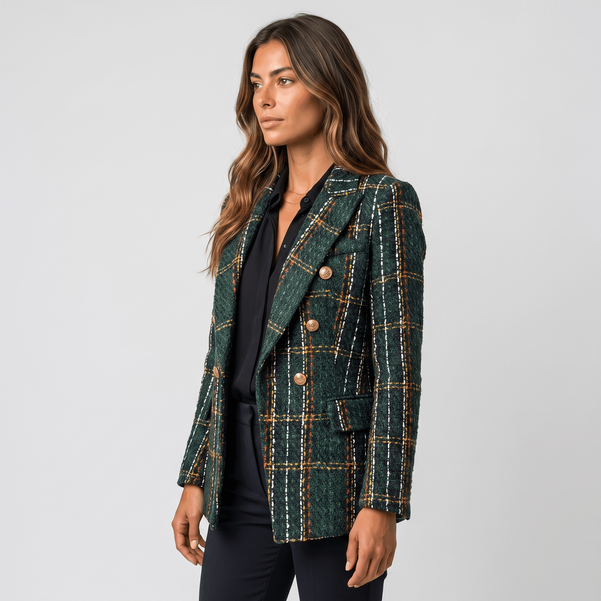 Side view of a woman wearing a dark green plaid tweed blazer with gold-tone buttons, notched lapels, and tailored fit.