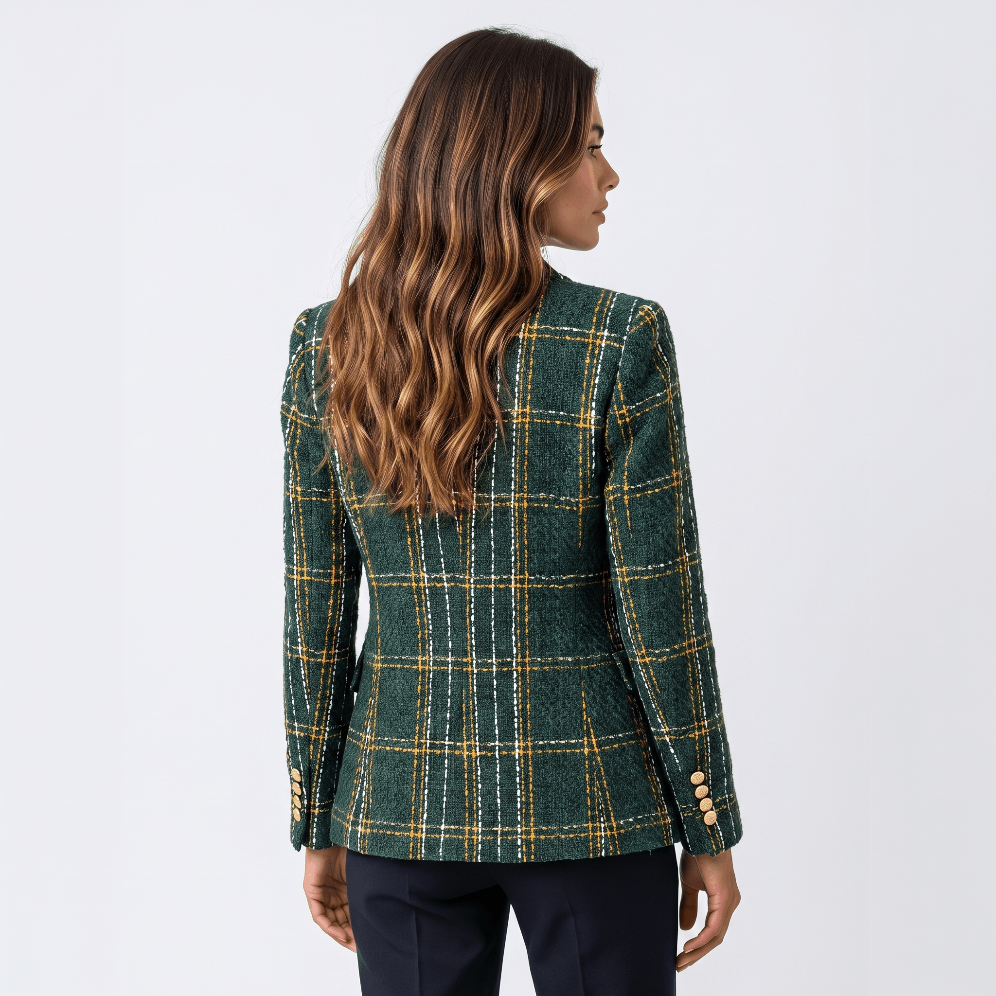 Back view of a woman wearing a dark green plaid tweed blazer featuring a tailored silhouette and long sleeves.