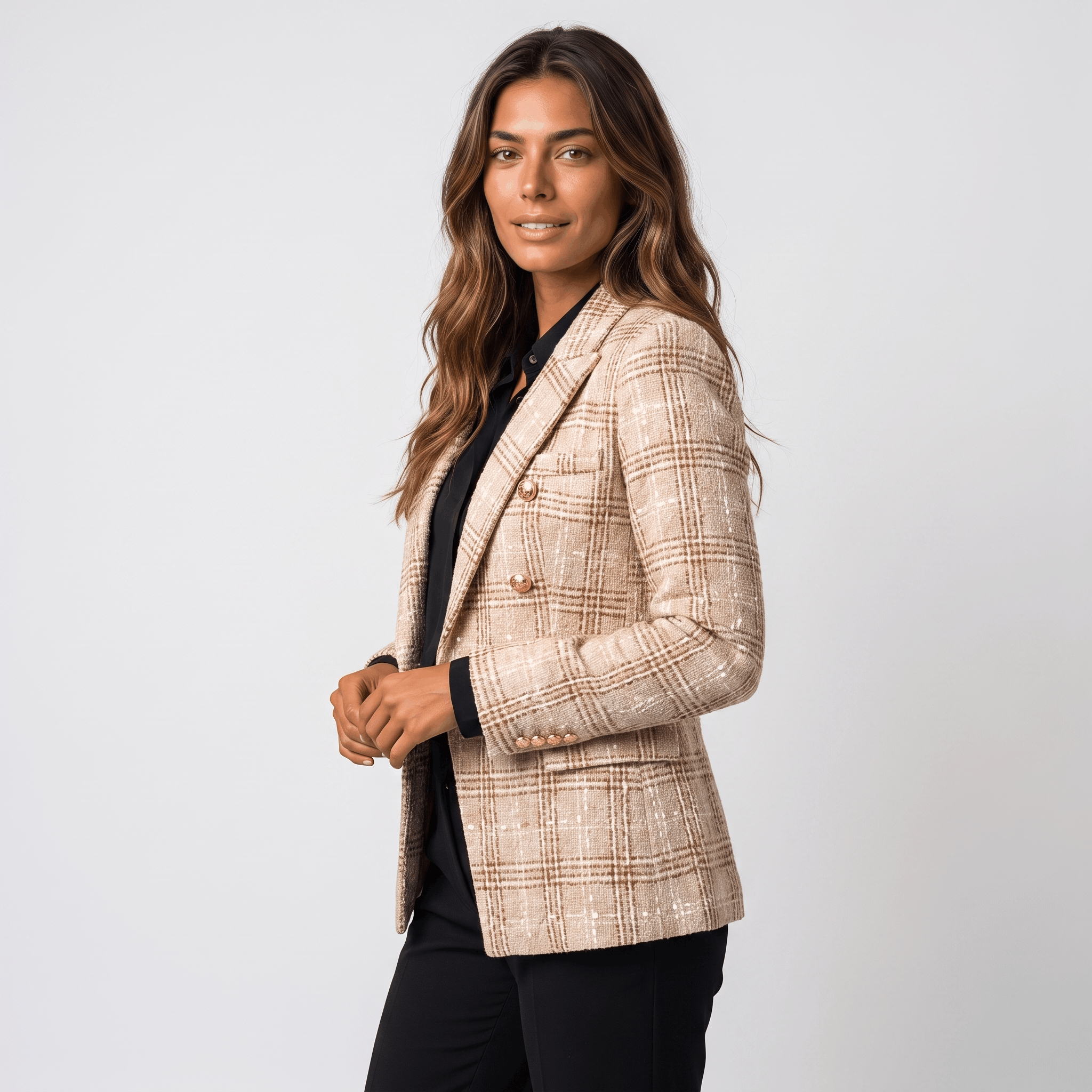 Side view of a woman wearing a beige plaid tweed blazer with a tailored silhouette, notched lapels, and gold-tone buttons.