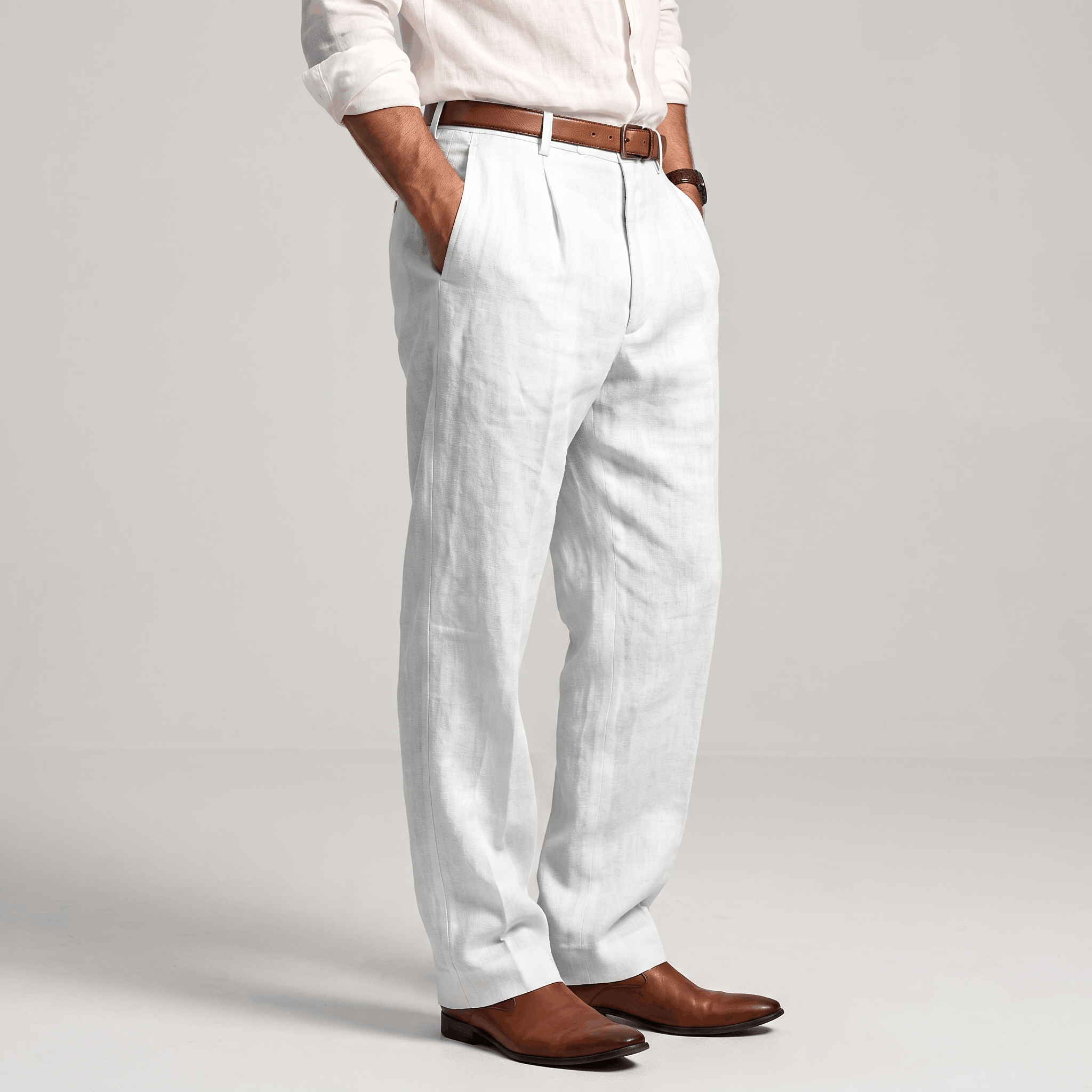 Side view of men's white linen pleated trousers featuring a tailored straight-leg silhouette and lightweight linen fabric.