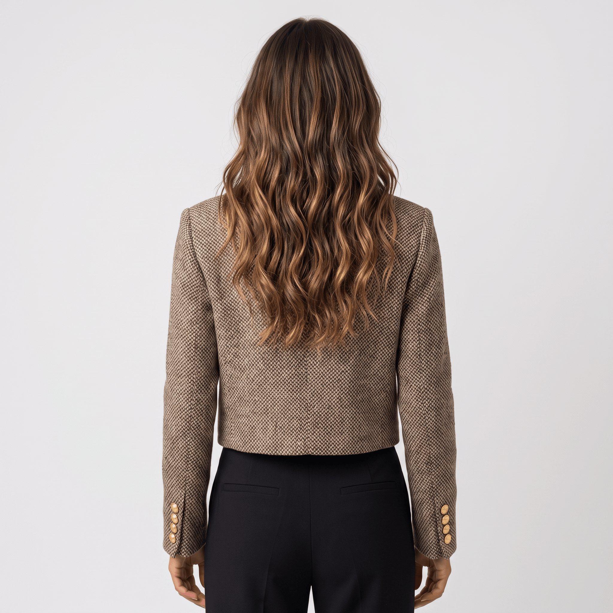 Back view of a woman wearing a brown textured tweed blazer with a tailored fit and long sleeves.