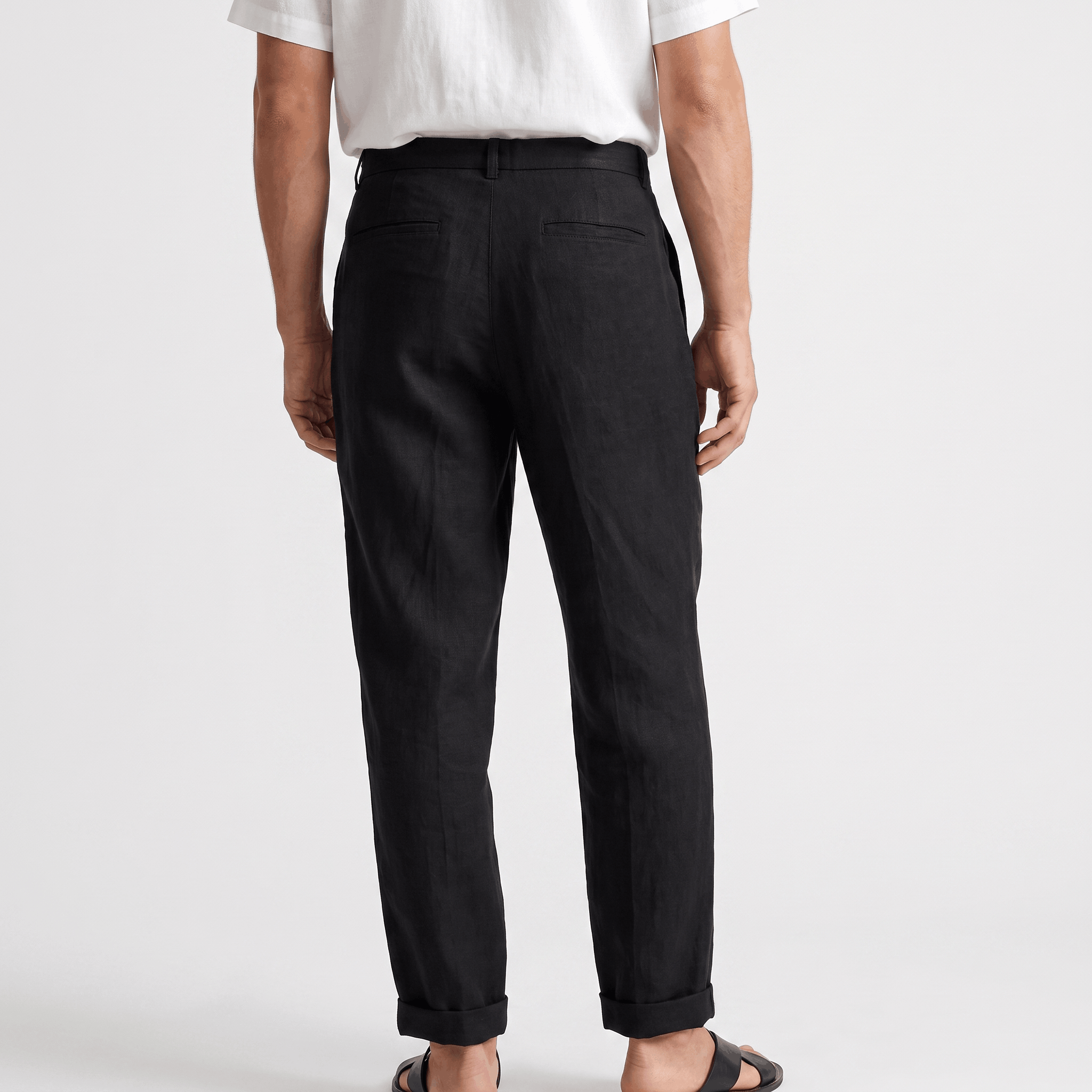 Back view of men's black linen pants with a straight-leg fit, belt loops, and clean minimalist design.