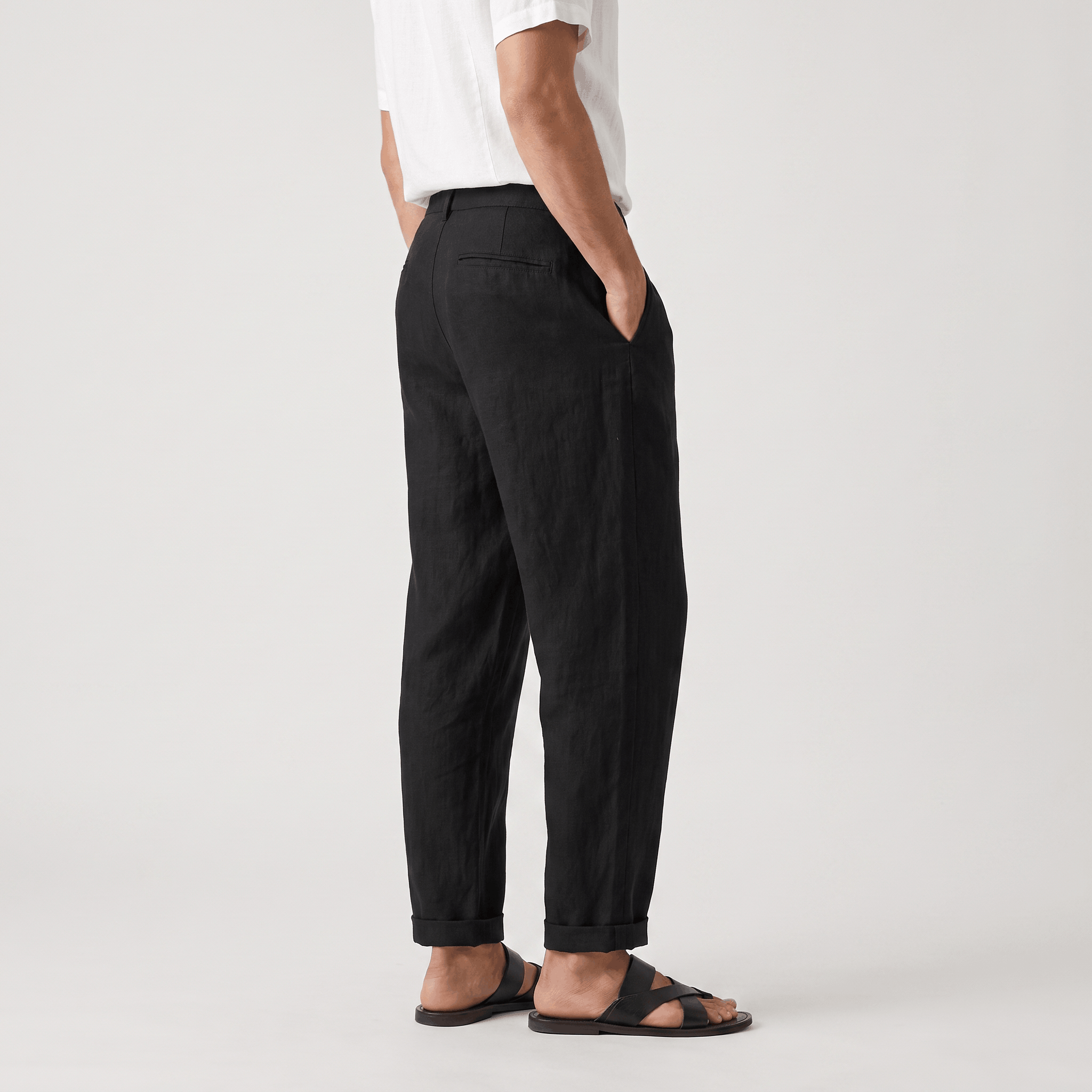 Side view of men's black linen pants featuring a tailored straight-leg silhouette and lightweight linen fabric.