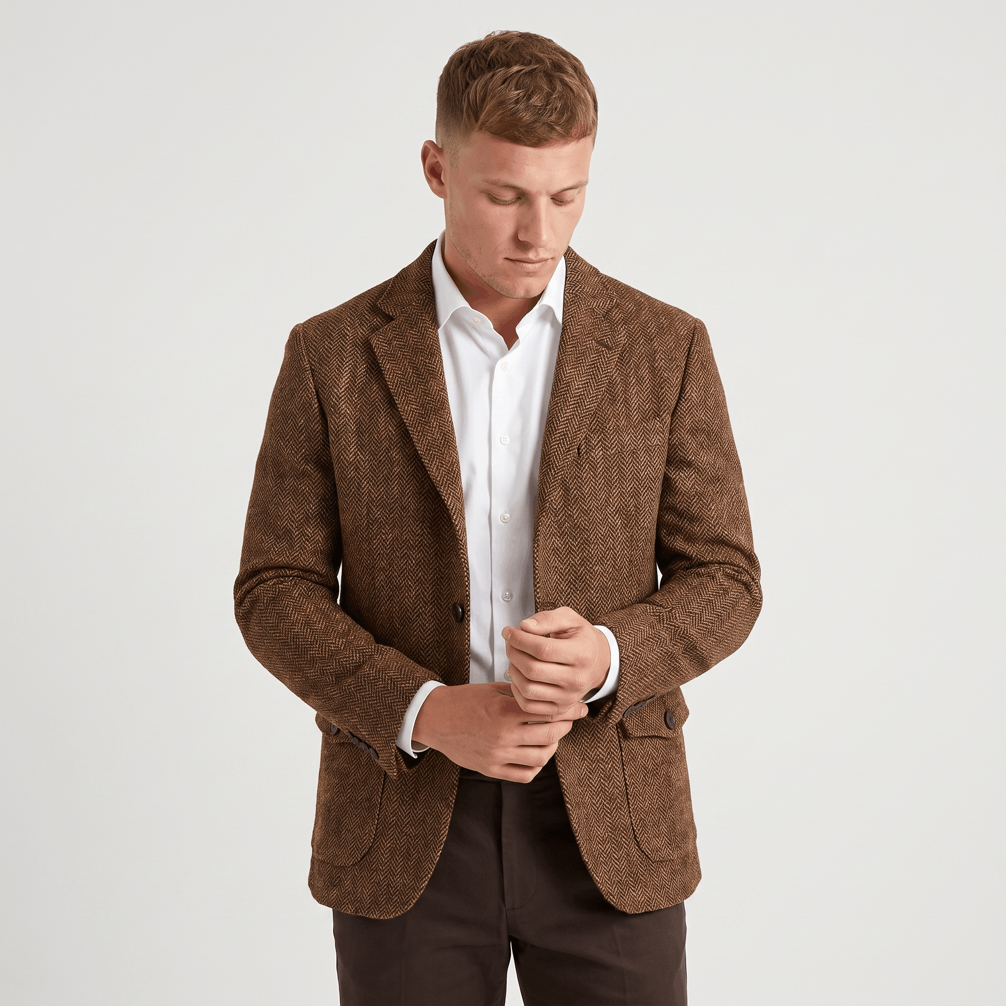 Front view of a man wearing a brown tweed blazer with a notched lapel, two-button closure, flap pockets, and tailored silhouette.