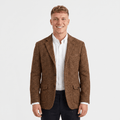Man wearing a brown textured tweed blazer with a notched lapel, two-button closure, flap pockets, and tailored fit over a white dress shirt and black trousers.