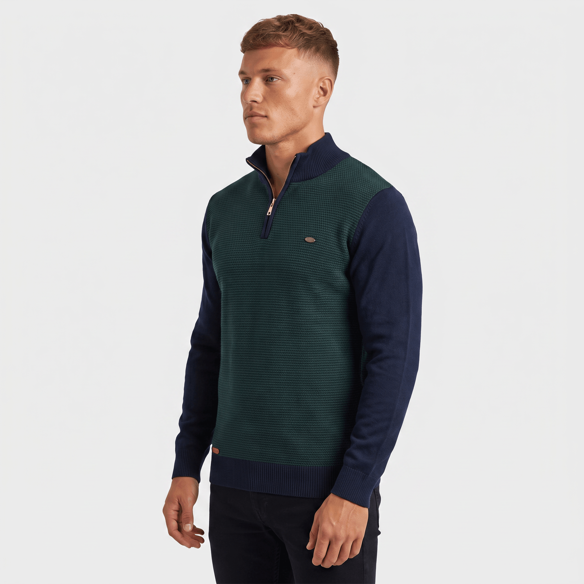Side view of a man wearing a green ribbed quarter-zip sweater with navy sleeves and a stand collar.