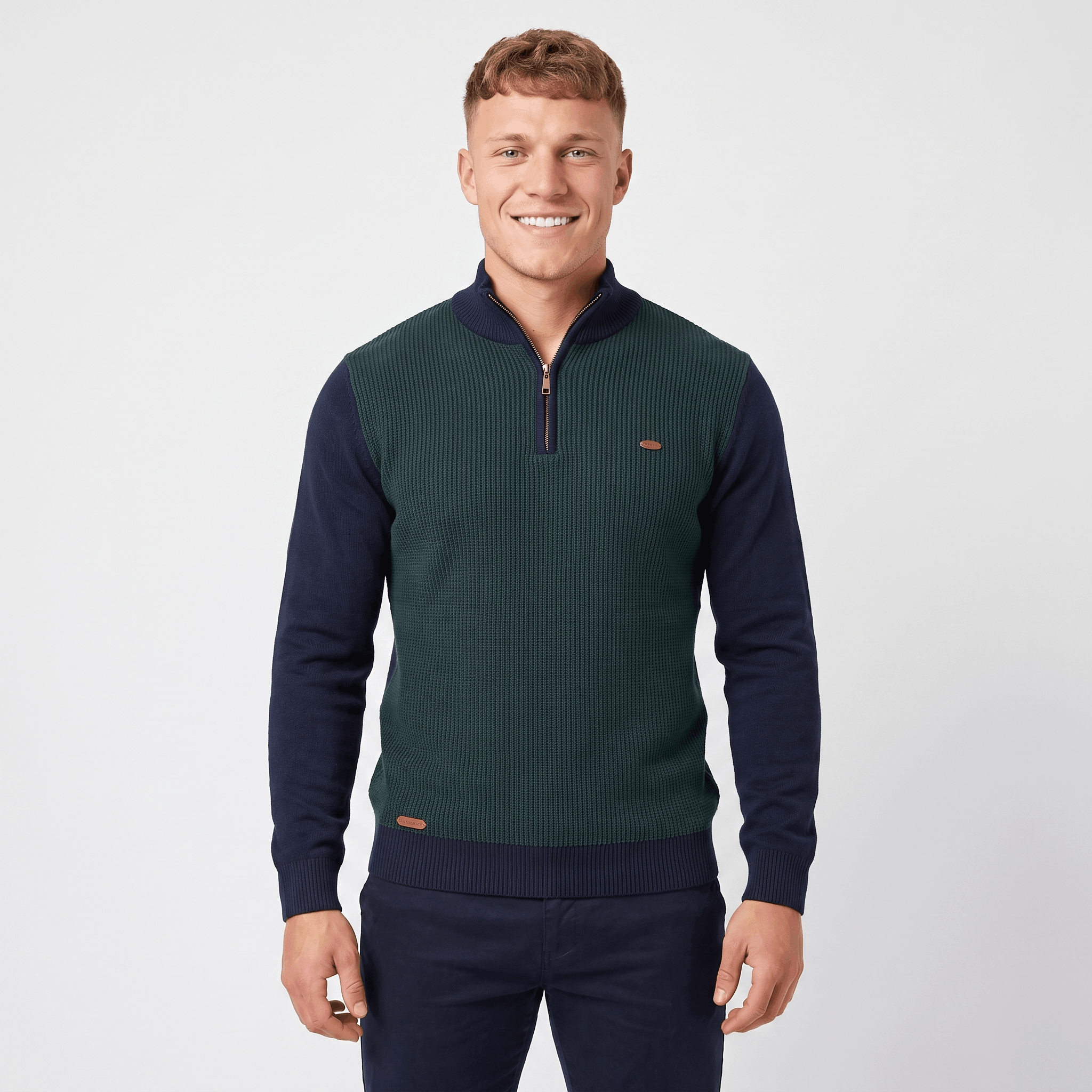 Man wearing a green color block quarter-zip knit sweater with navy sleeves, ribbed texture, stand collar, and long sleeves.