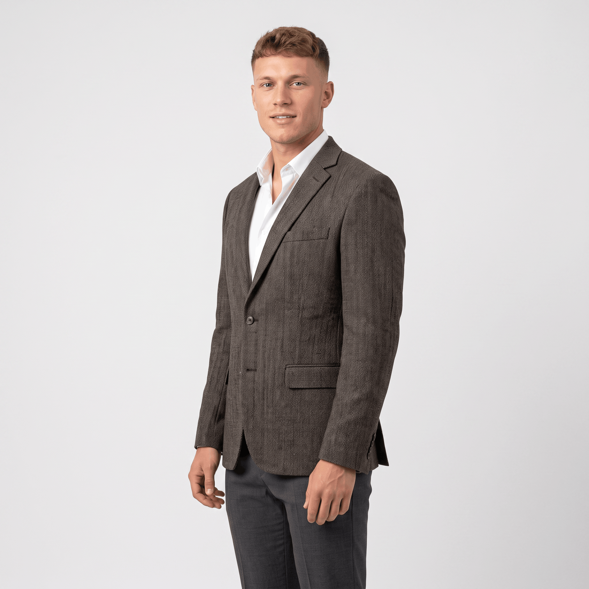 Side view of a man wearing a gray tweed blazer with a notched lapel, button closure, and tailored silhouette.