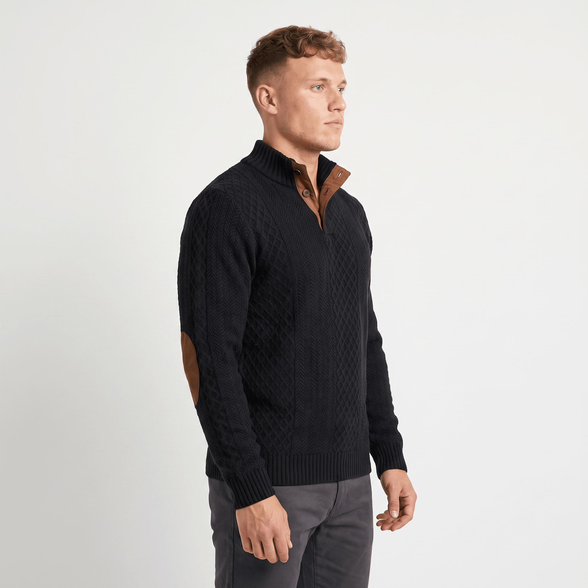 Side view of a man wearing a black cable knit Henley sweater featuring a stand collar, textured knit pattern, and faux suede elbow patches.