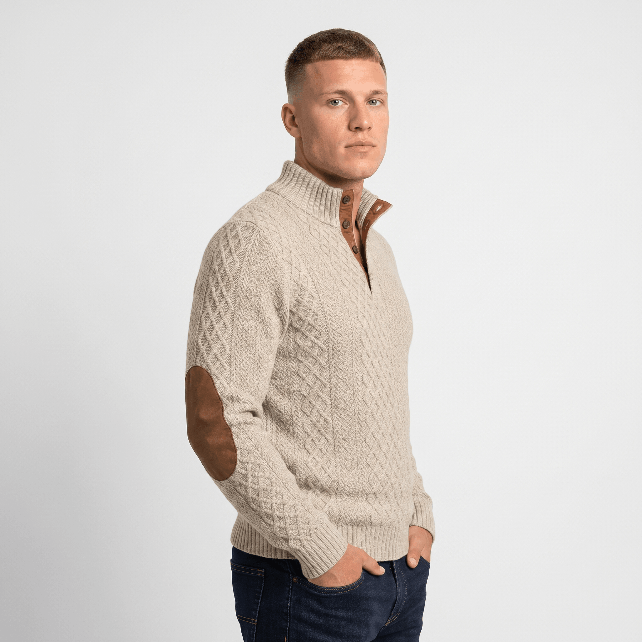 Side view of a man wearing a cream cable knit Henley sweater featuring a stand collar, button placket, and faux suede elbow patches.