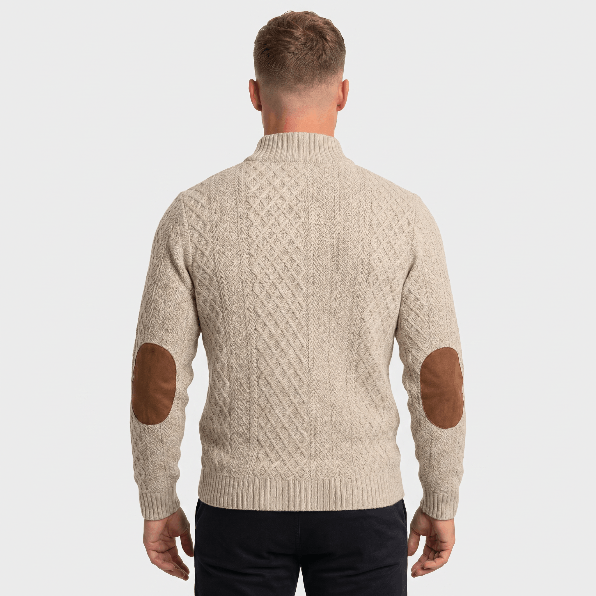 Man wearing a gray cable knit Henley sweater with a stand collar, button placket, faux suede elbow patches, and a modern fit.